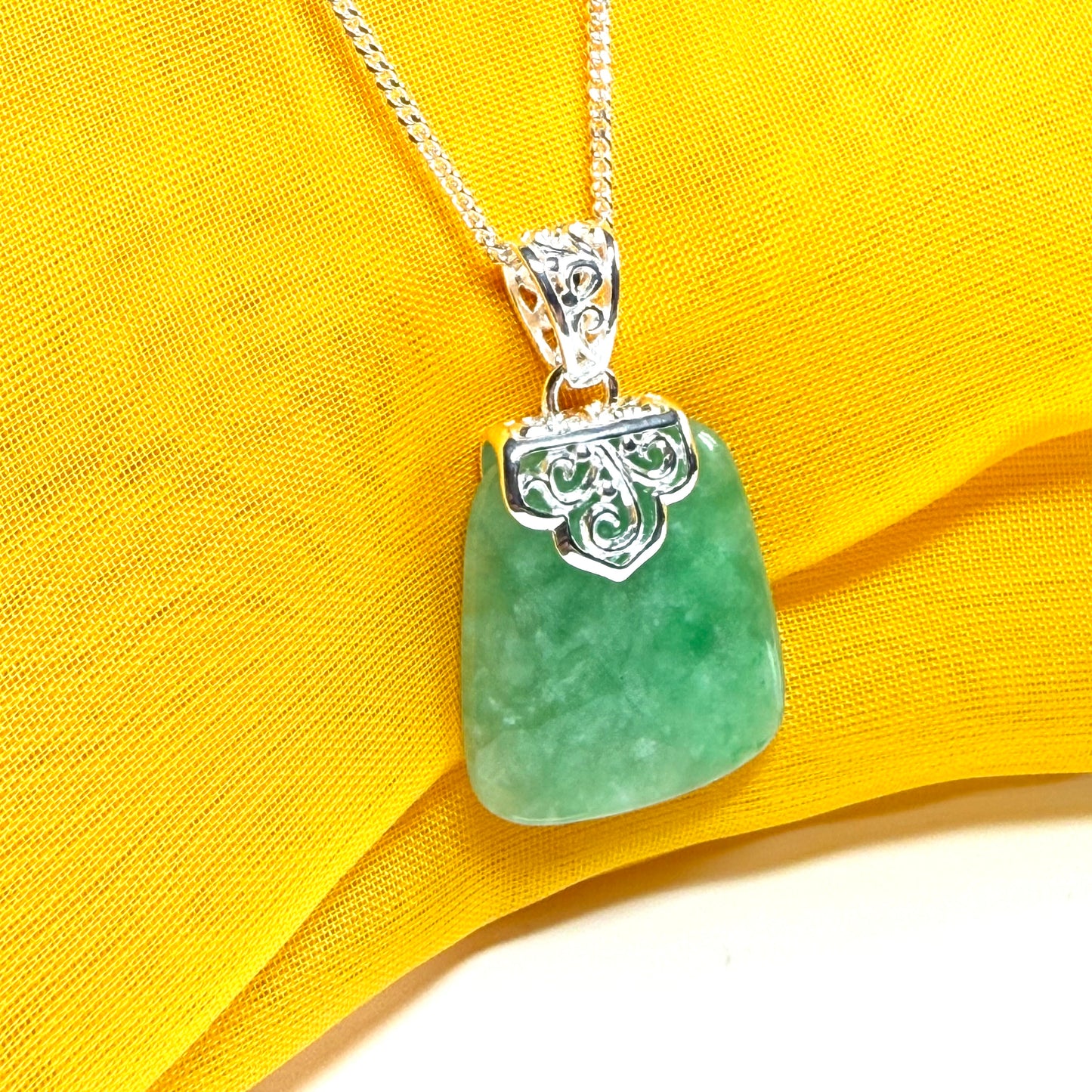 A real green jade necklace sterling silver large cushion shaped including a curb chain, a beautiful pendant