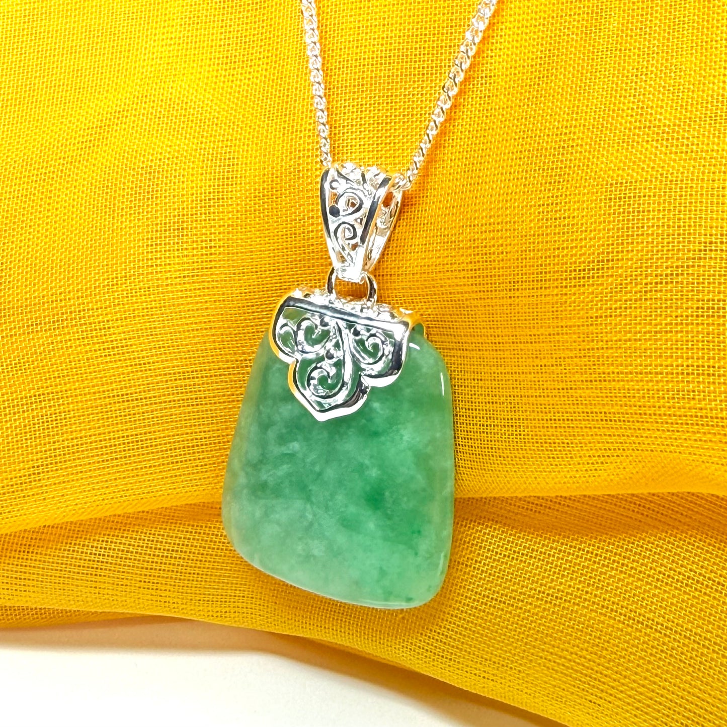 A real green jade necklace sterling silver large cushion shaped including a curb chain, a beautiful pendant