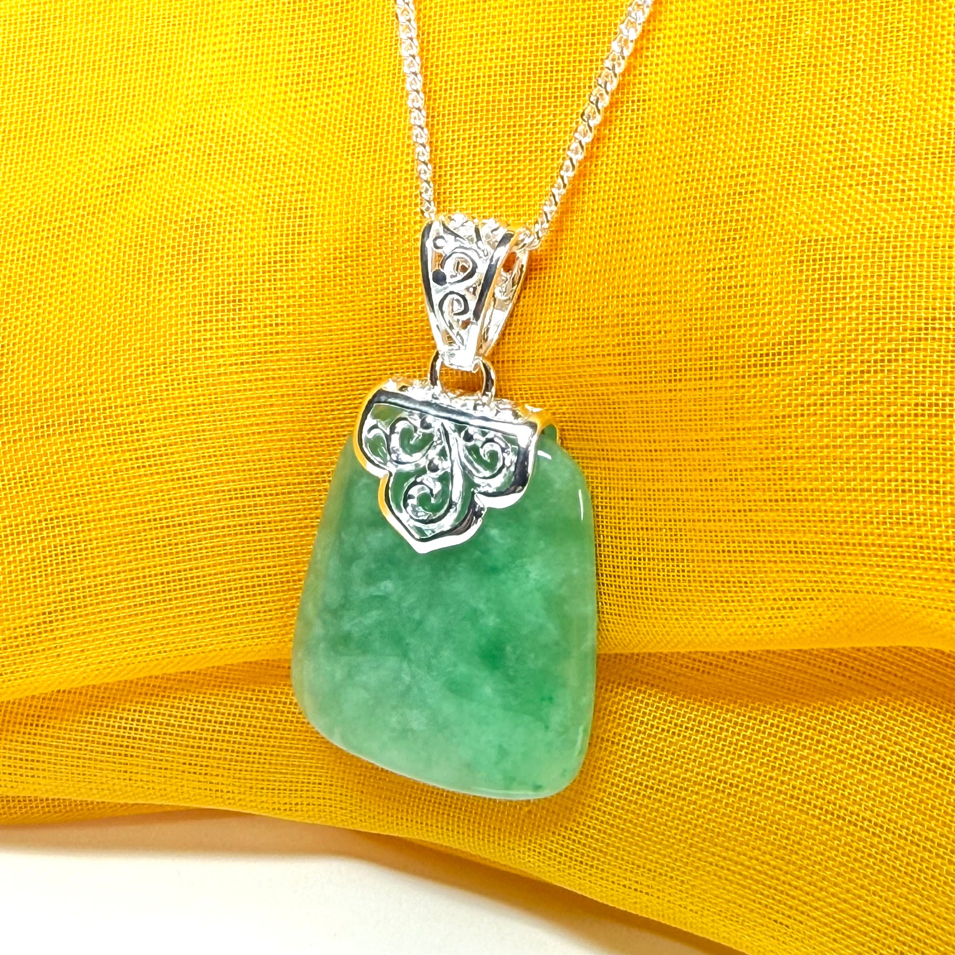 A real green jade necklace sterling silver large cushion shaped including a curb chain, a beautiful pendant