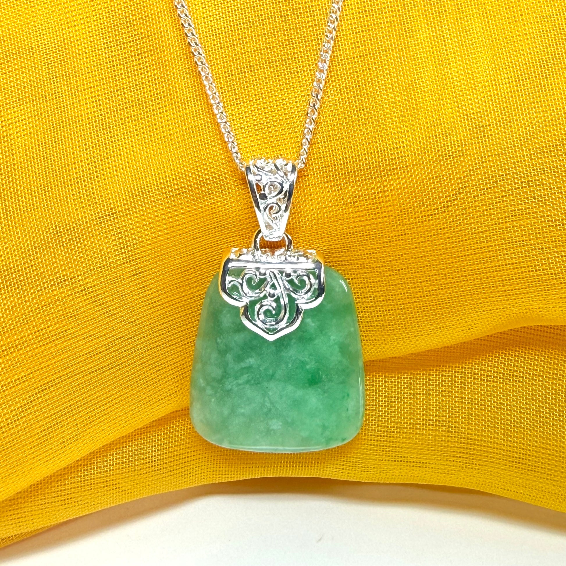 A real green jade necklace sterling silver large cushion shaped including a curb chain, a beautiful pendant