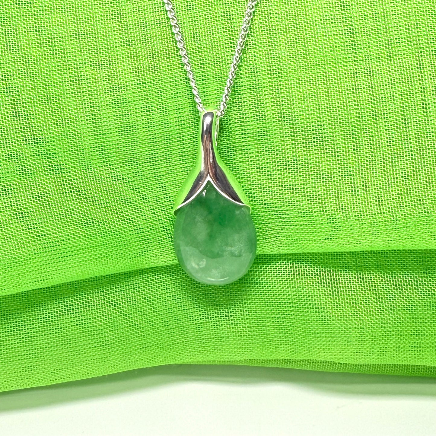 A real green jade necklace teardrop with a pear shaped pendant, with chain included