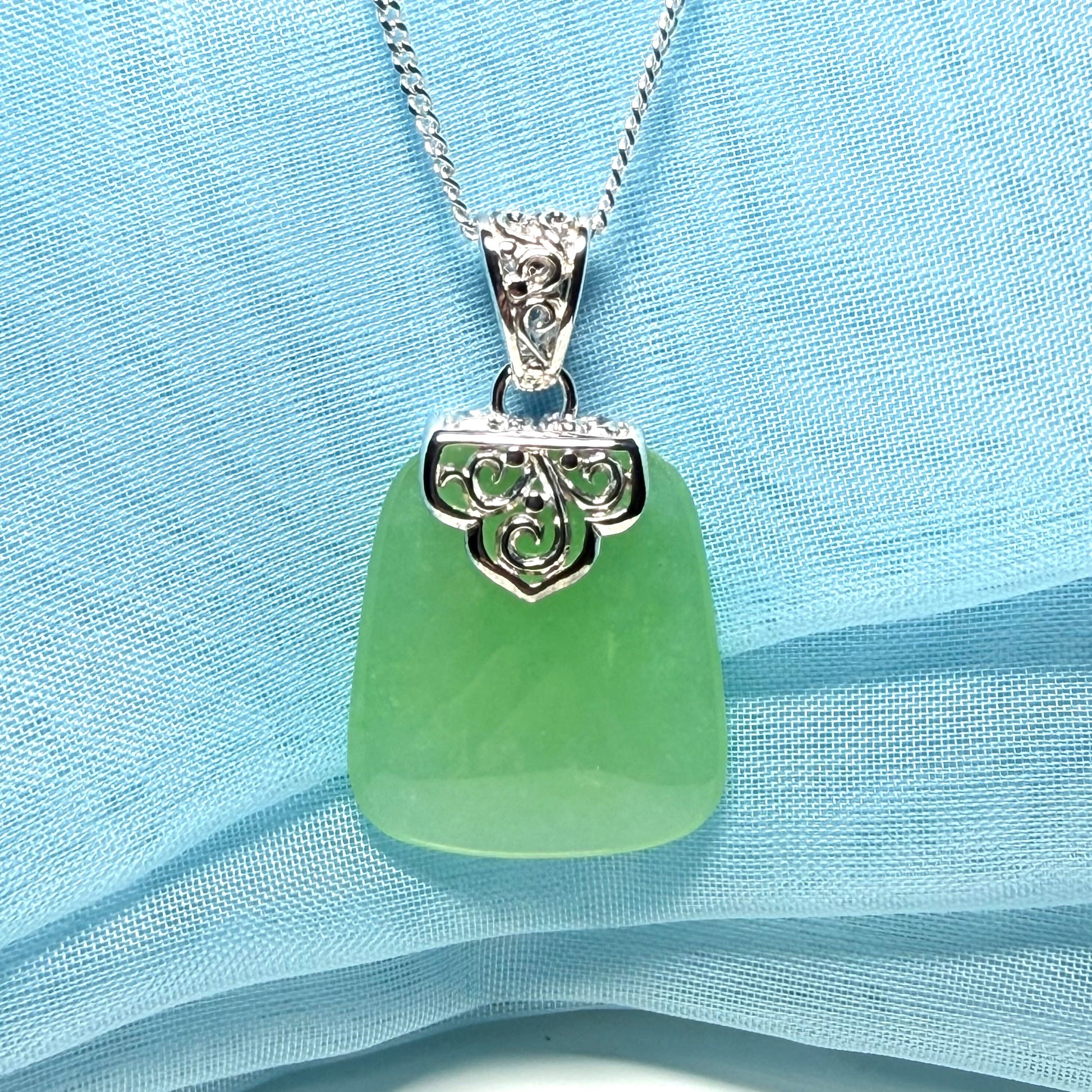 Real green jade necklace with a large shaped and patterned top pendant with chain