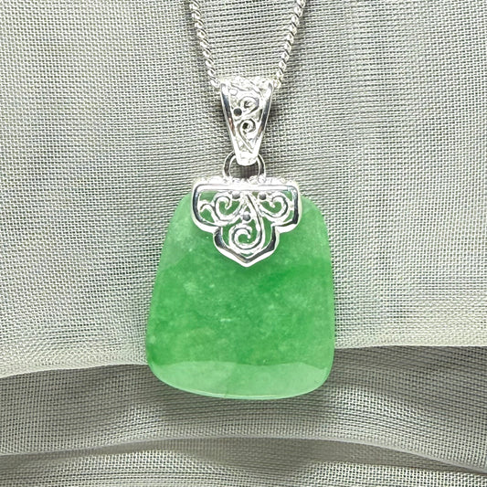 A real green jade necklace with a large shaped and patterned pendant