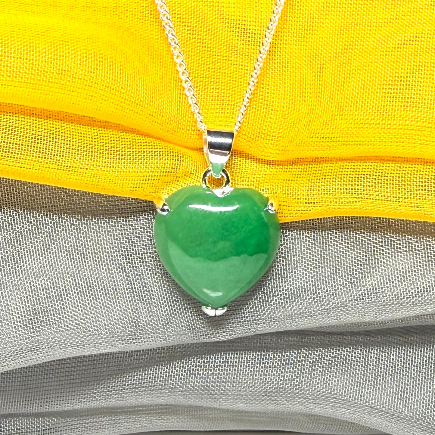 A real green jade pendant heart shaped sterling silver, a traditional design