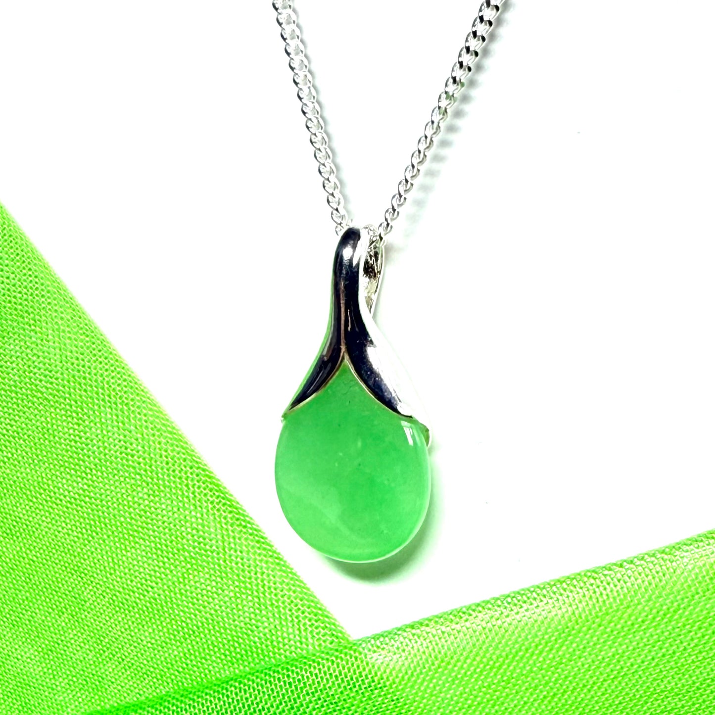 A real green jade pendant necklace in a teardrop shaped or pear shaped design to it