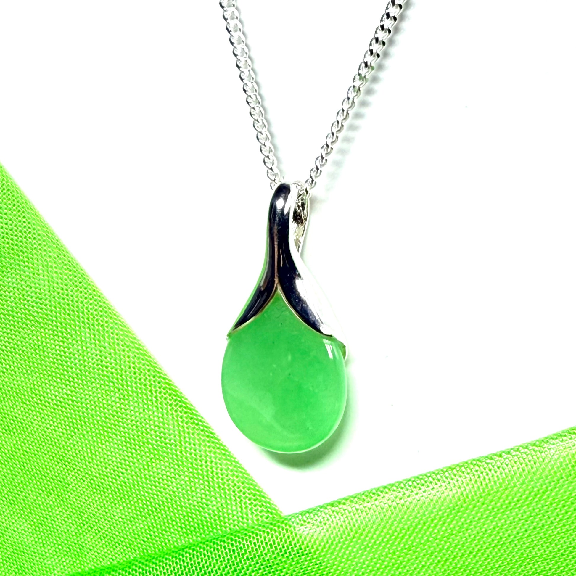 A real green jade pendant necklace in a teardrop shaped or pear shaped design to it