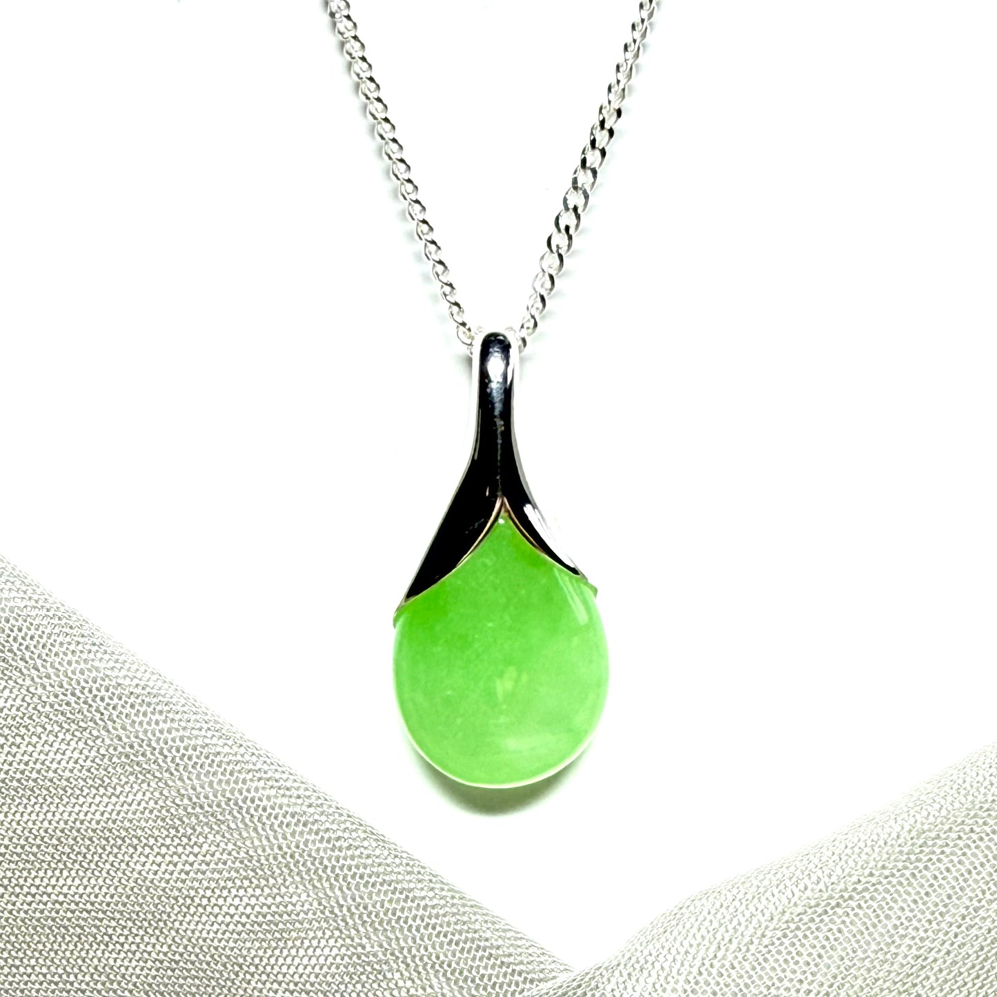 A real green jade pendant necklace in a teardrop shape or pear shaped design