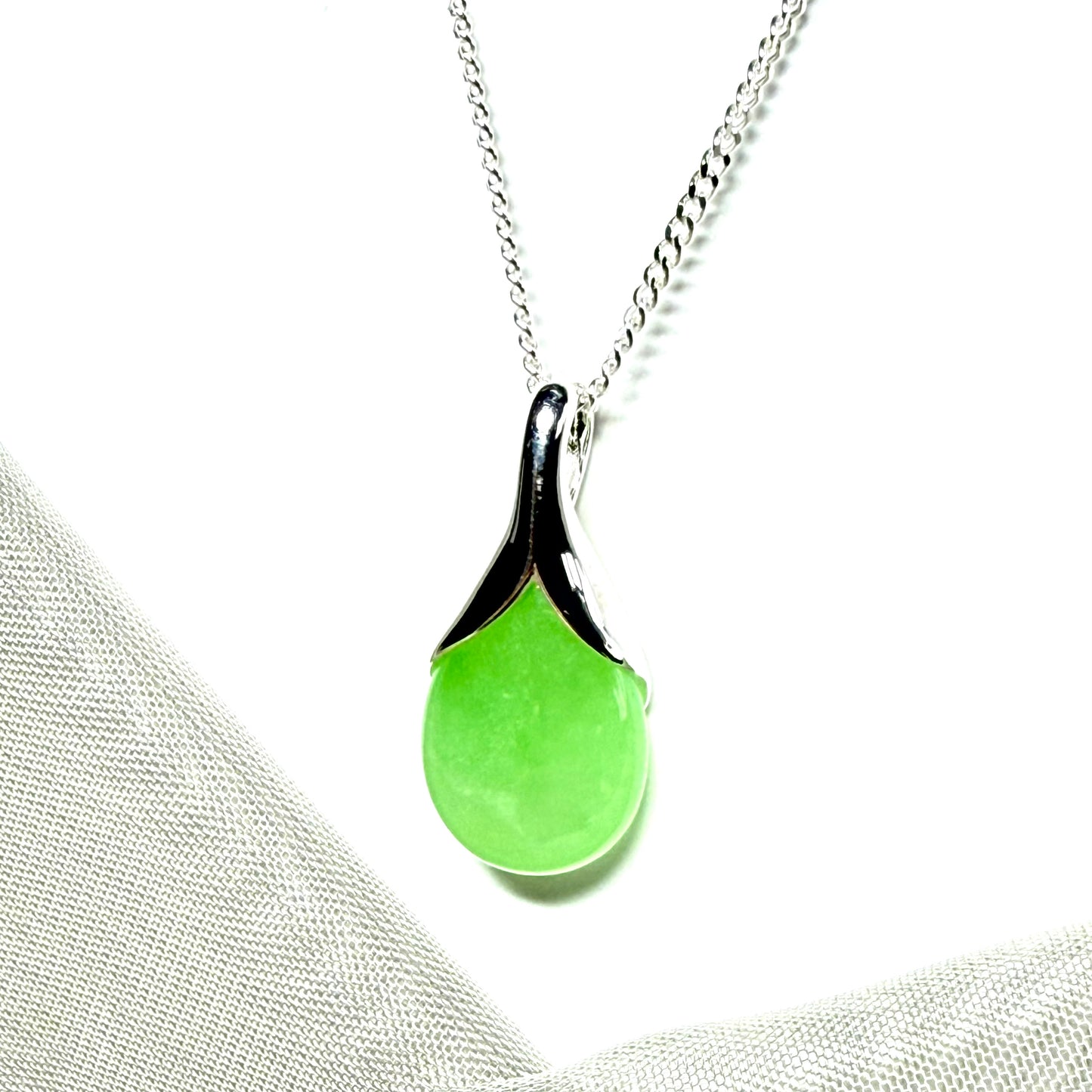 A real green jade pendant necklace in a teardrop shape or pear shaped design