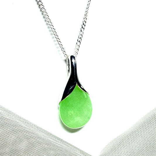 A real green jade pendant necklace in a teardrop shape or pear shaped design