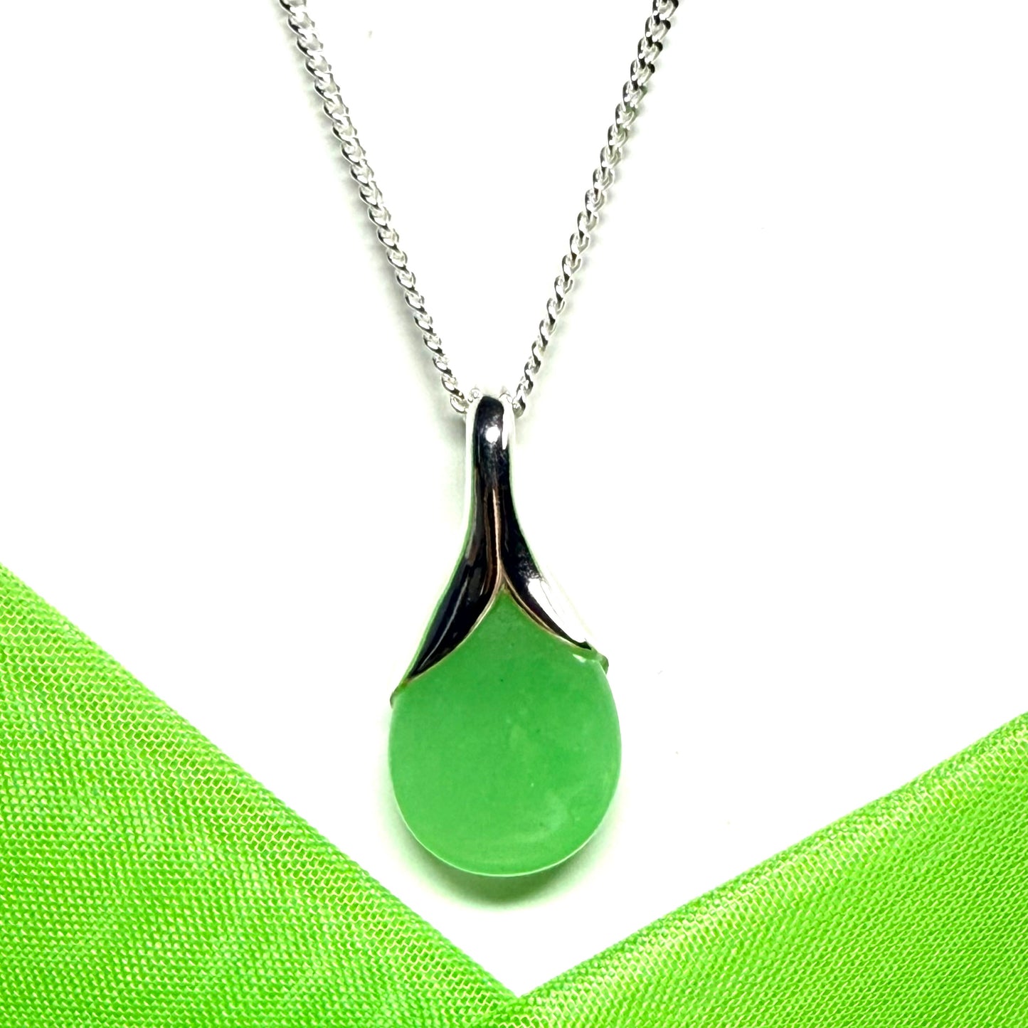 A real green jade pendant necklace in a teardrop shaped or pear shaped design to it