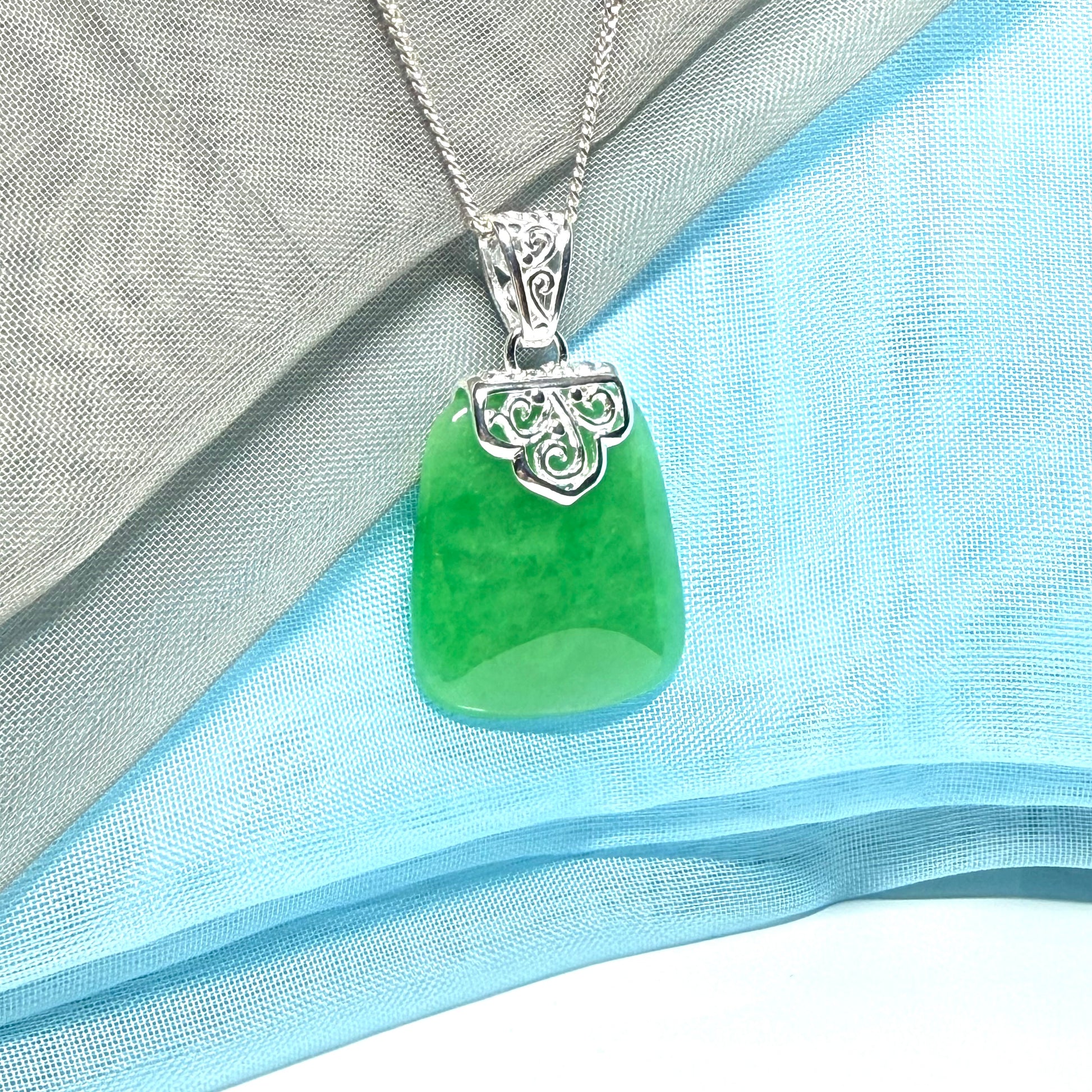 A stunning real green jade necklace with a large shaped and patterned pendant