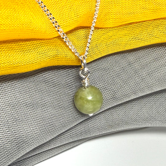 A small real green gypsum necklace ball shaped, a traditional round pendant