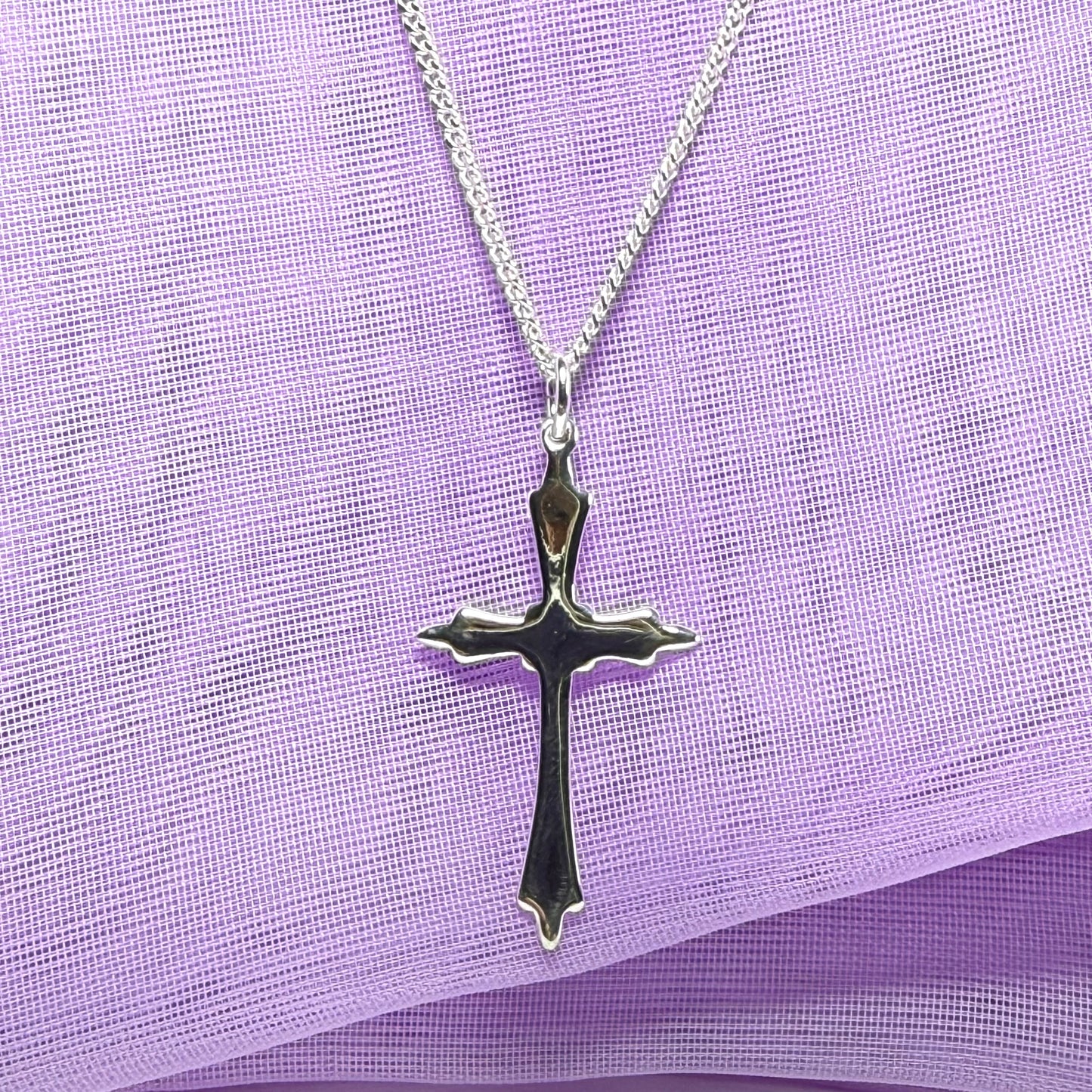 A solid fancy shaped sterling silver cross necklace pendant with a chain included