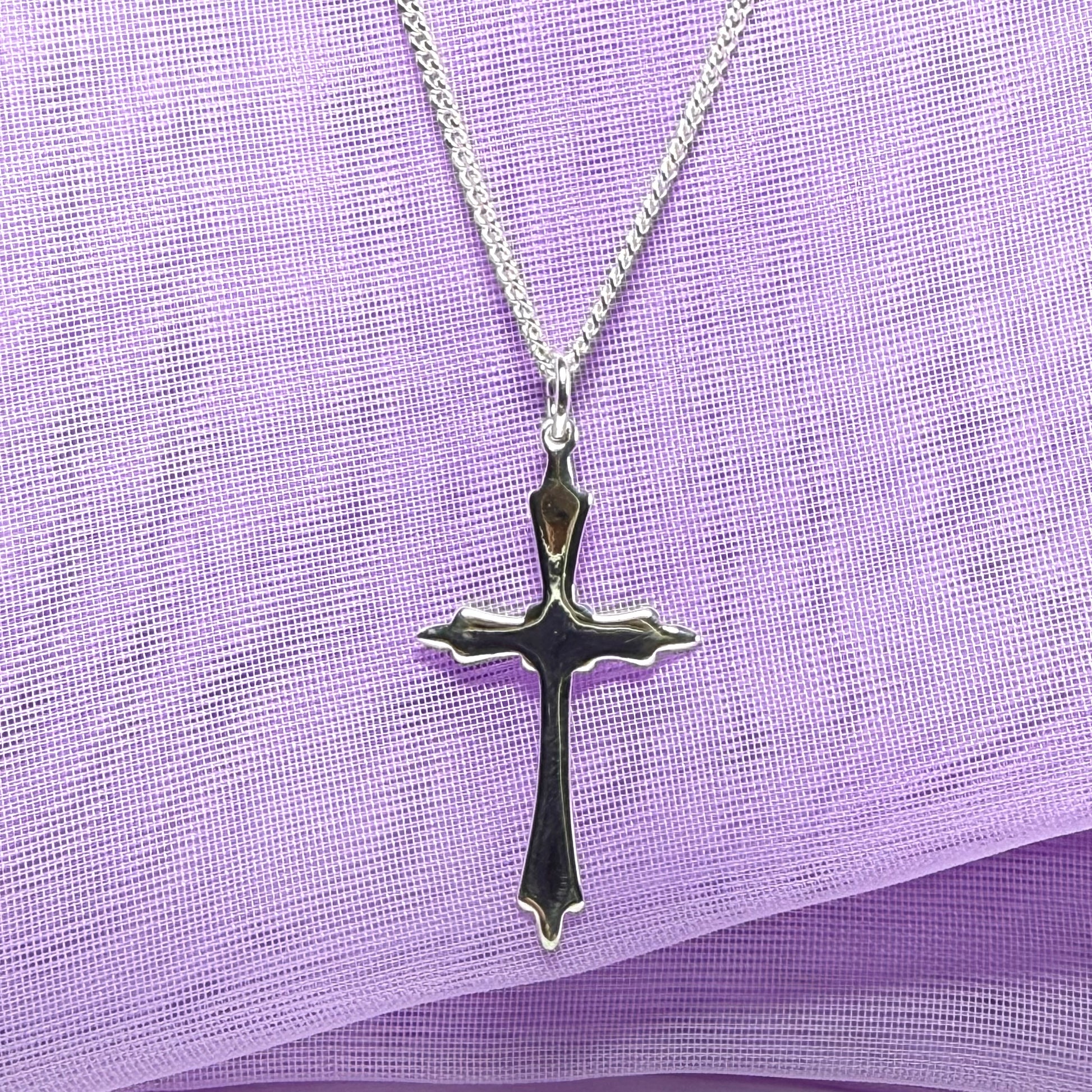 A solid fancy shaped sterling silver cross necklace pendant with a chain included