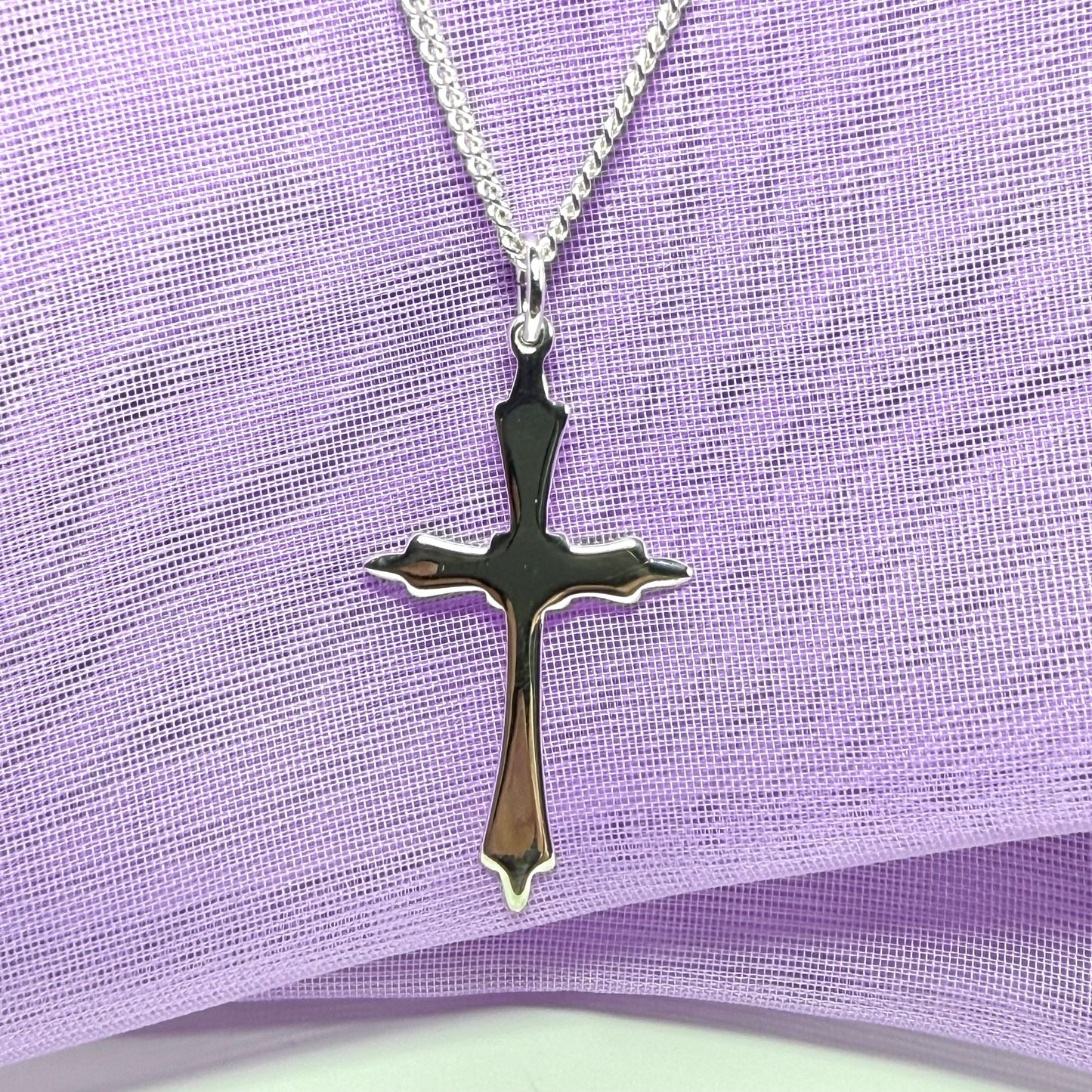 A solid fancy shaped sterling silver cross necklace pendant with a chain included