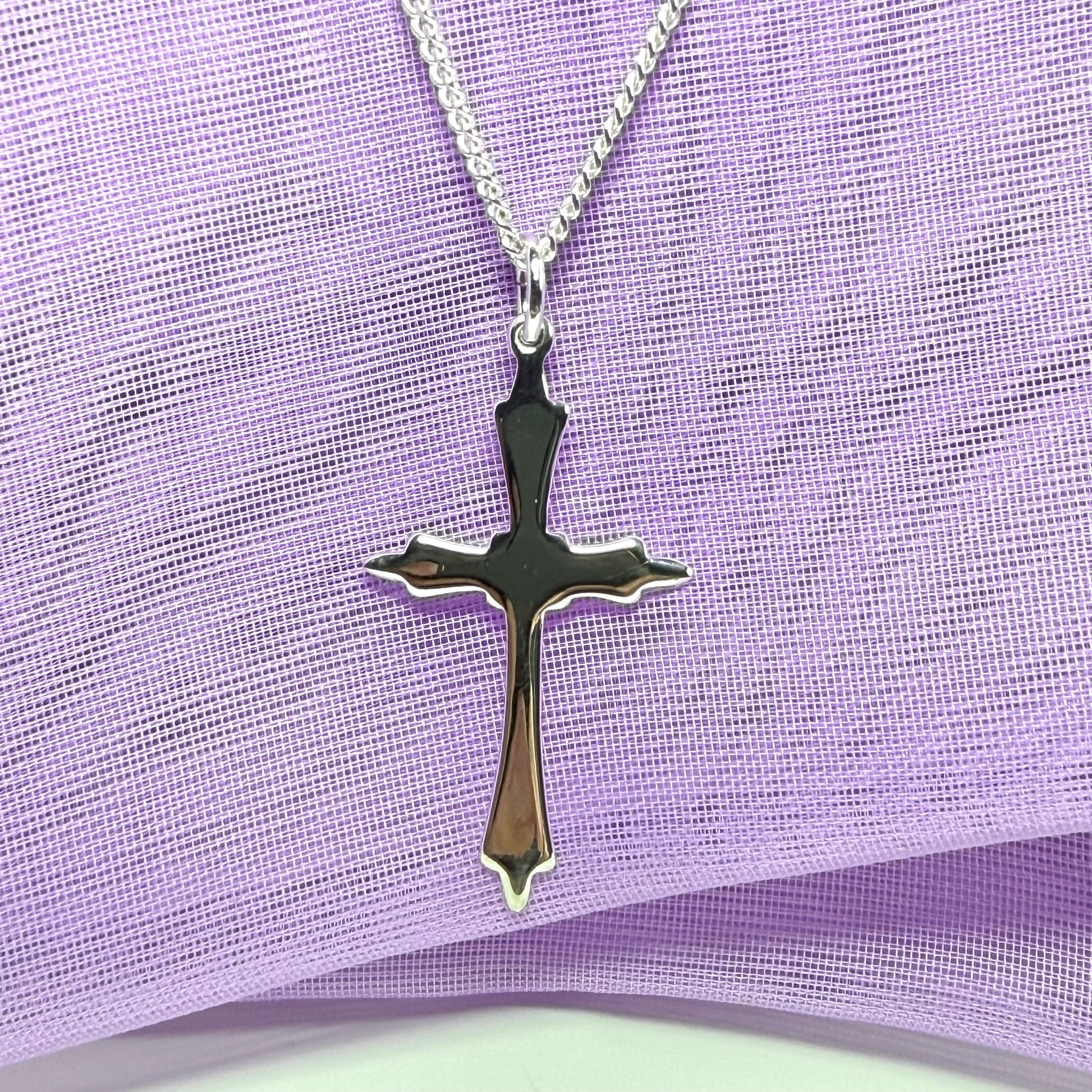 A solid fancy shaped sterling silver cross necklace pendant with a chain included