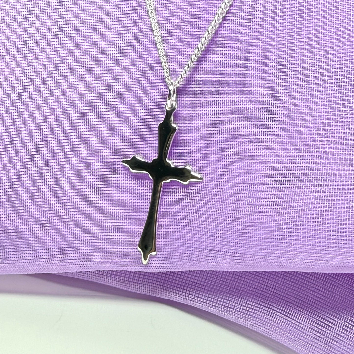 A solid fancy shaped sterling silver cross necklace pendant with a chain included