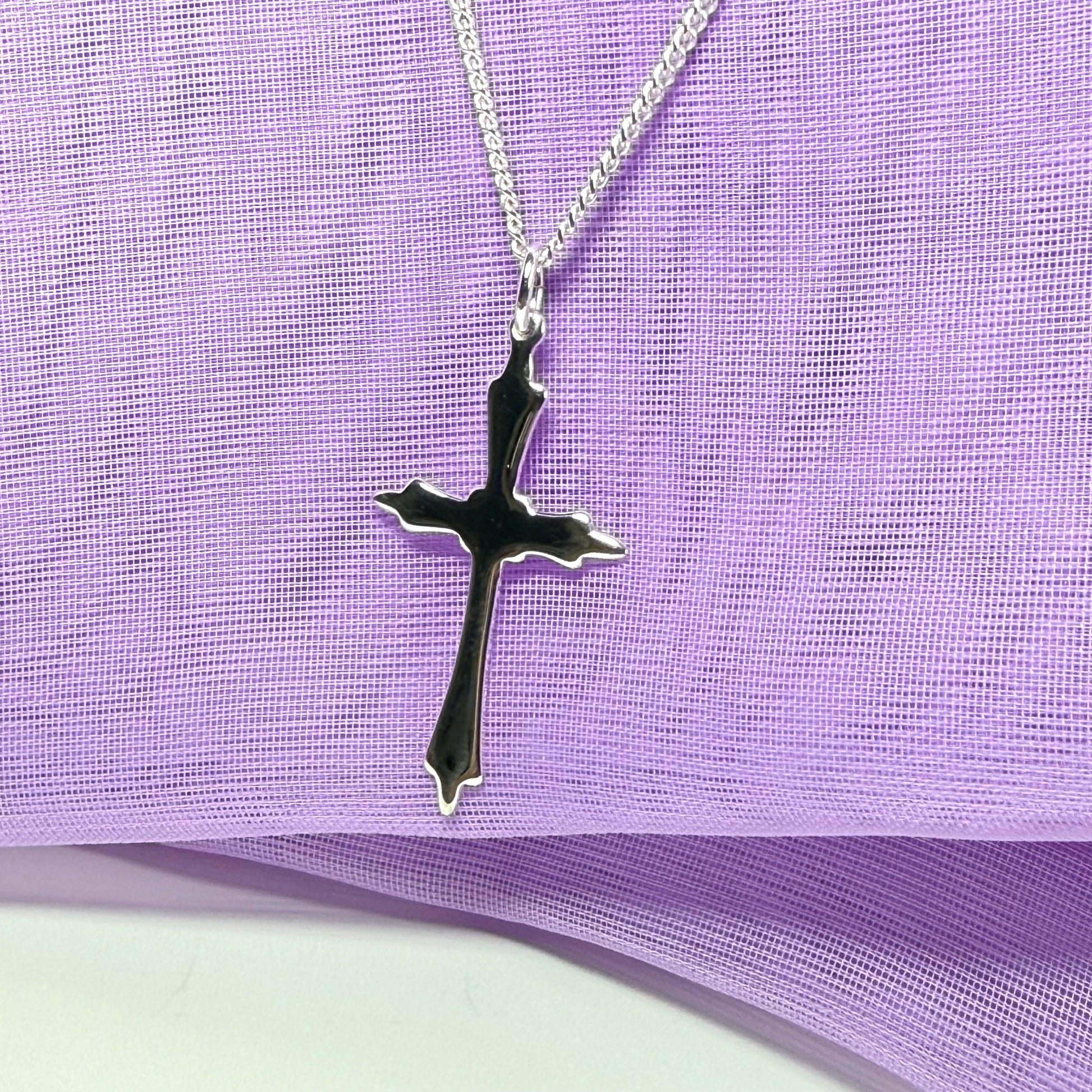 A solid fancy shaped sterling silver cross necklace pendant with a chain included