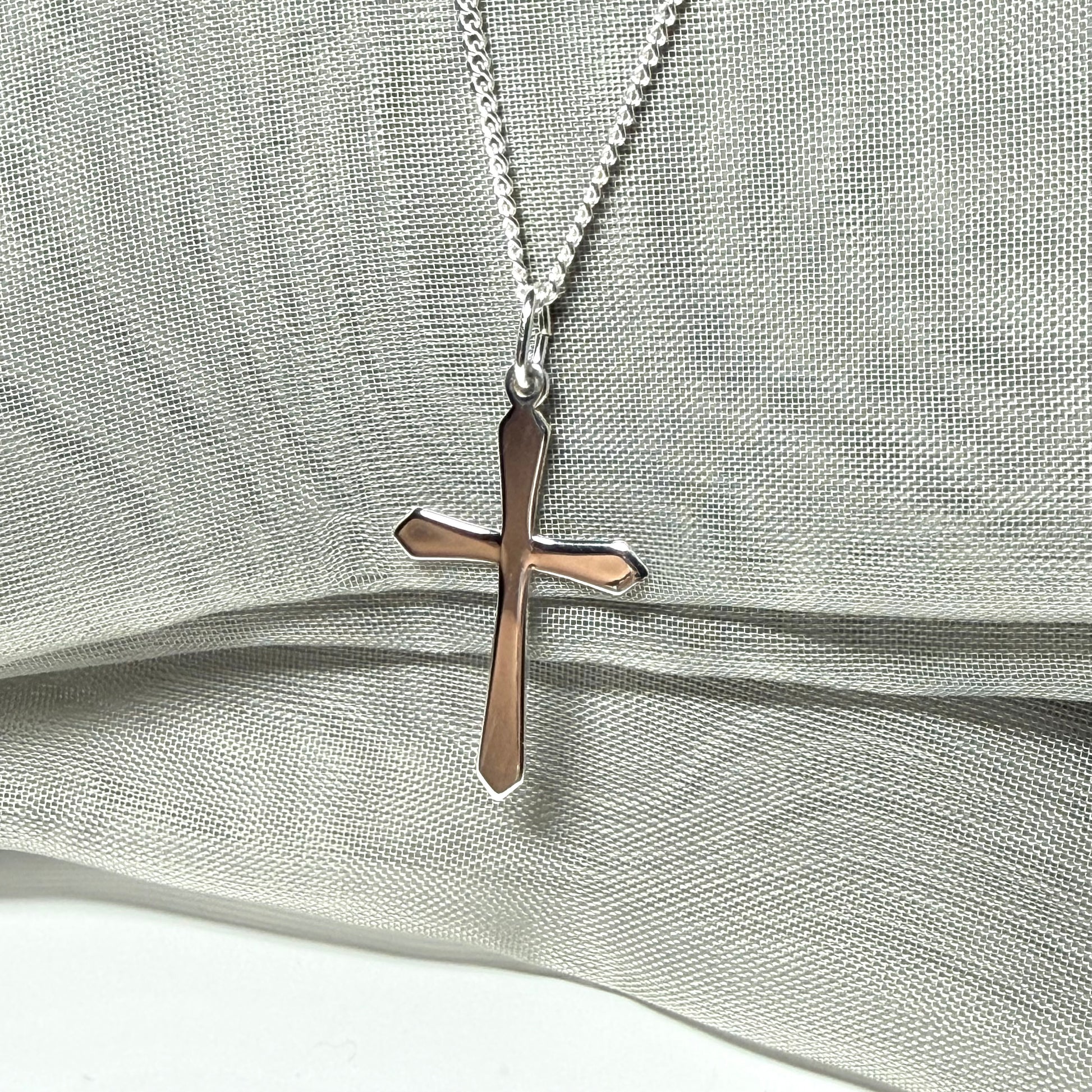 A solid sterling silver cross necklace fancy shaped pendant with a chain