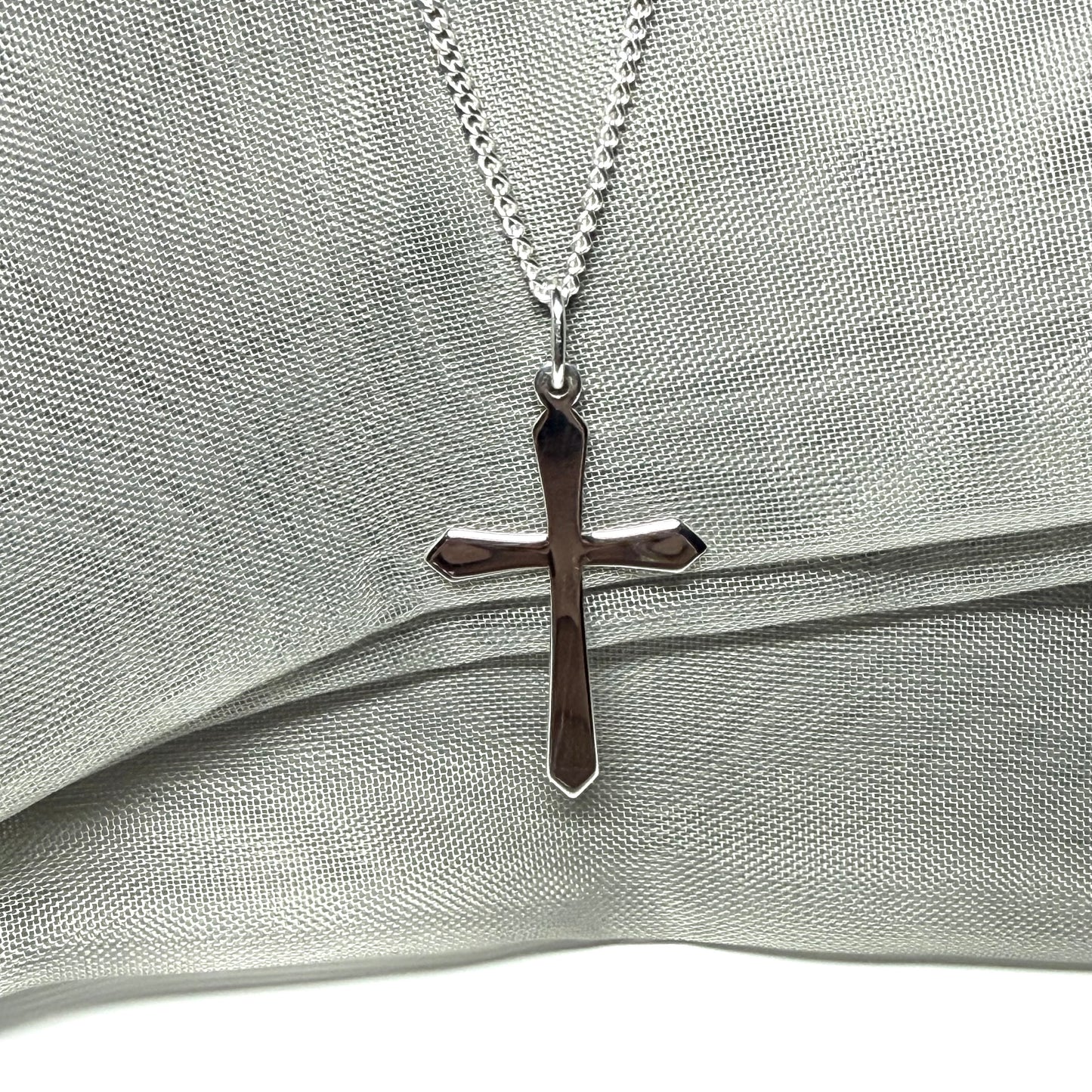 A solid sterling silver cross necklace fancy shaped pendant with a chain