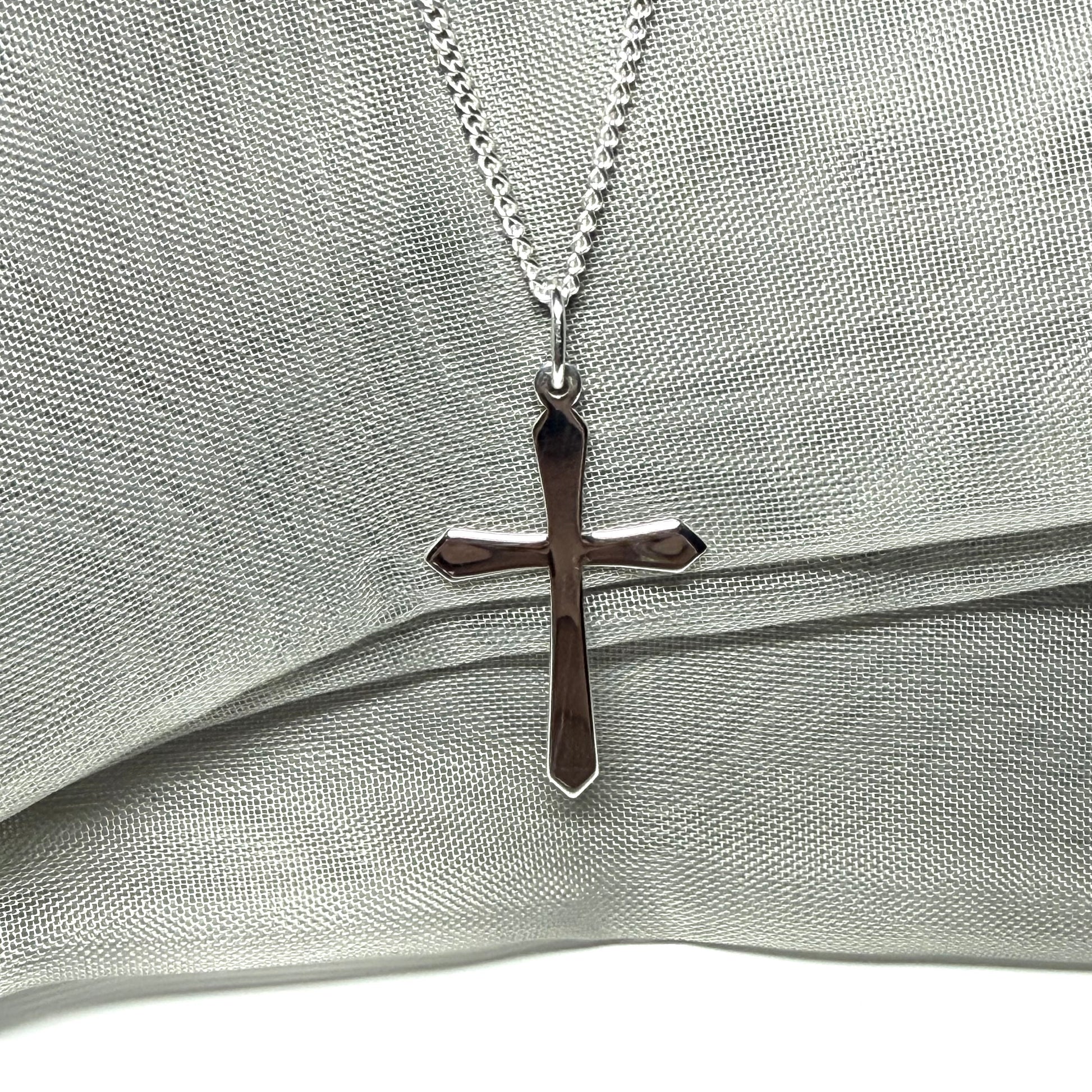 A solid sterling silver cross necklace fancy shaped pendant with a chain