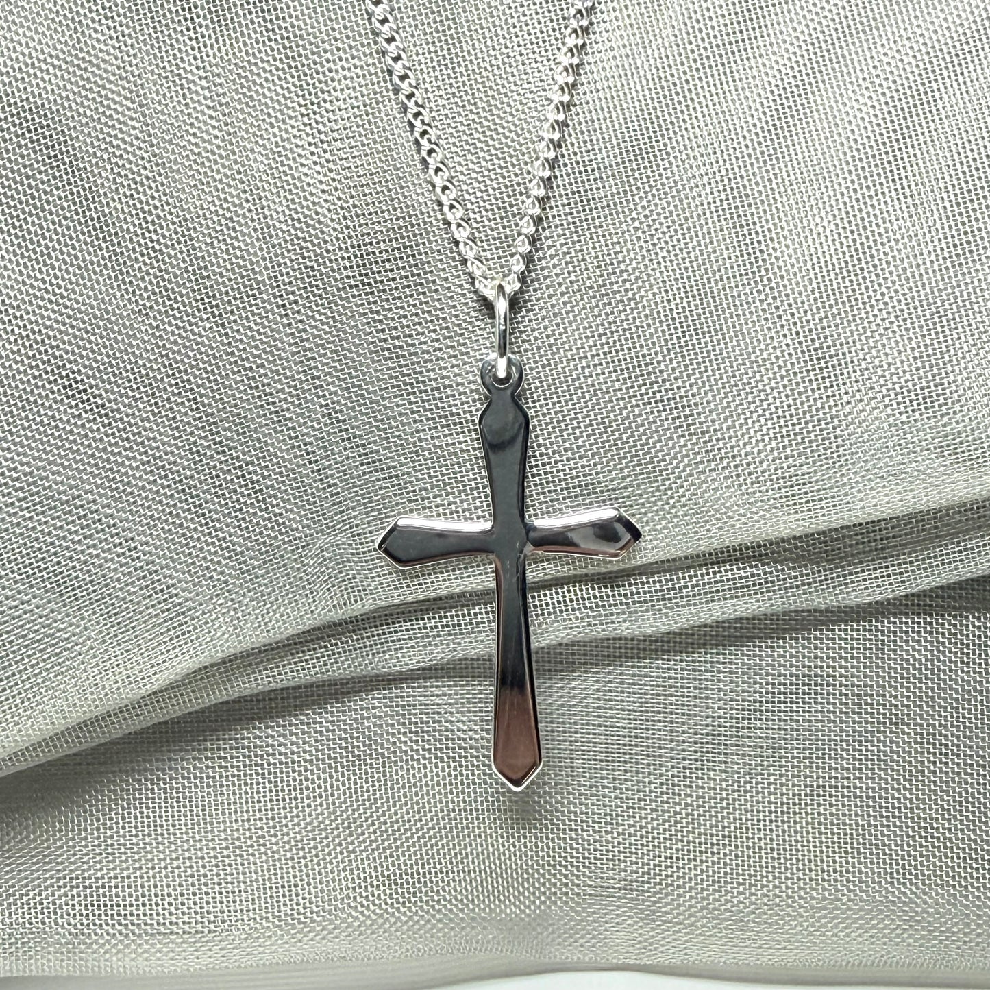 A solid sterling silver cross necklace fancy shaped pendant with a chain