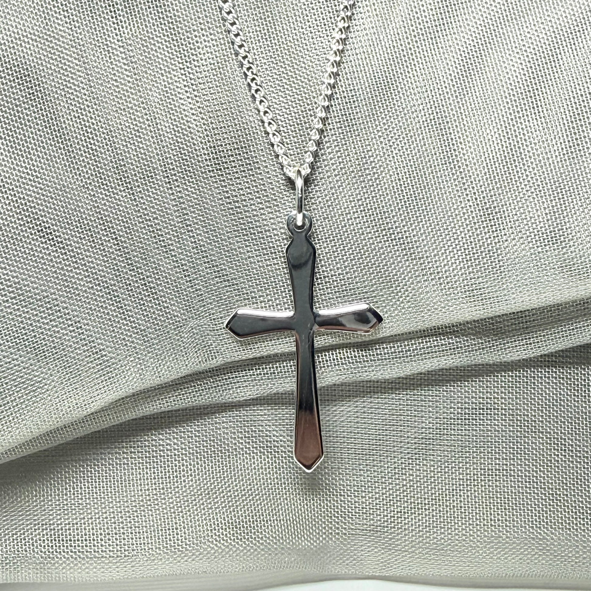 A solid sterling silver cross necklace fancy shaped pendant with a chain