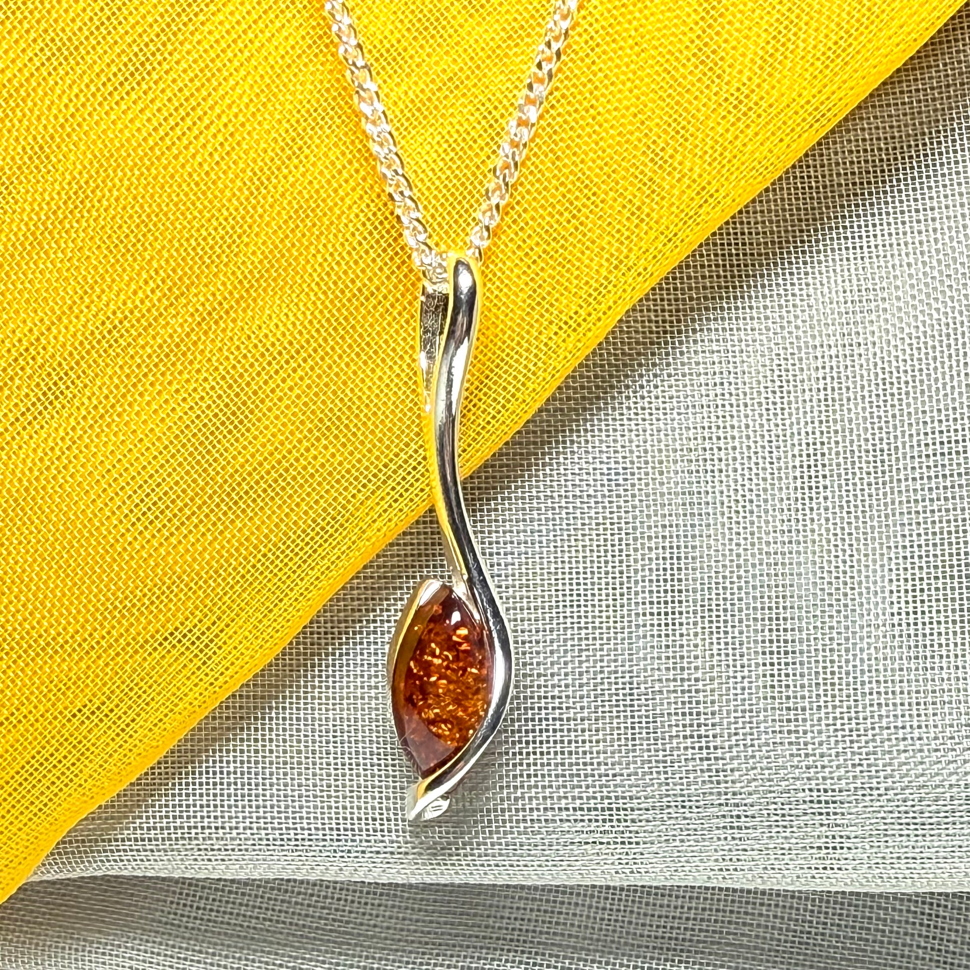 A Sterling silver real amber marquise shaped necklace swirled pendant