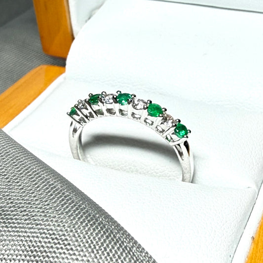 A stunning real emerald and diamond white gold eternity ring claw setting