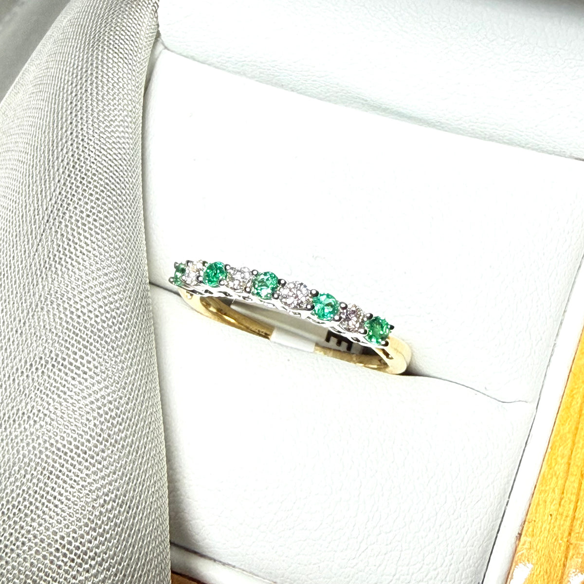 A stunning real emerald and diamond yellow gold eternity ring claw setting