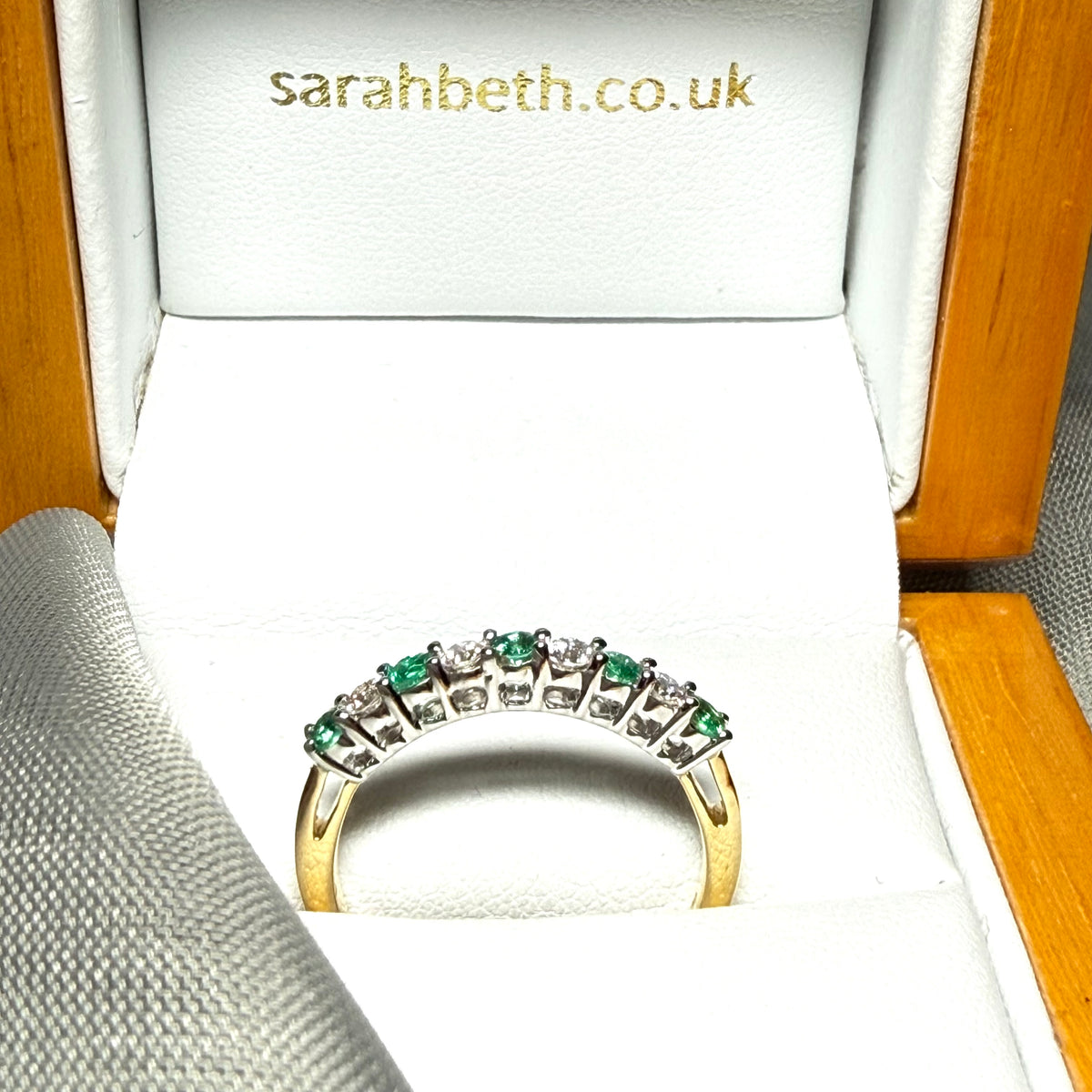 A stunning real emerald and diamond yellow gold eternity ring claw setting