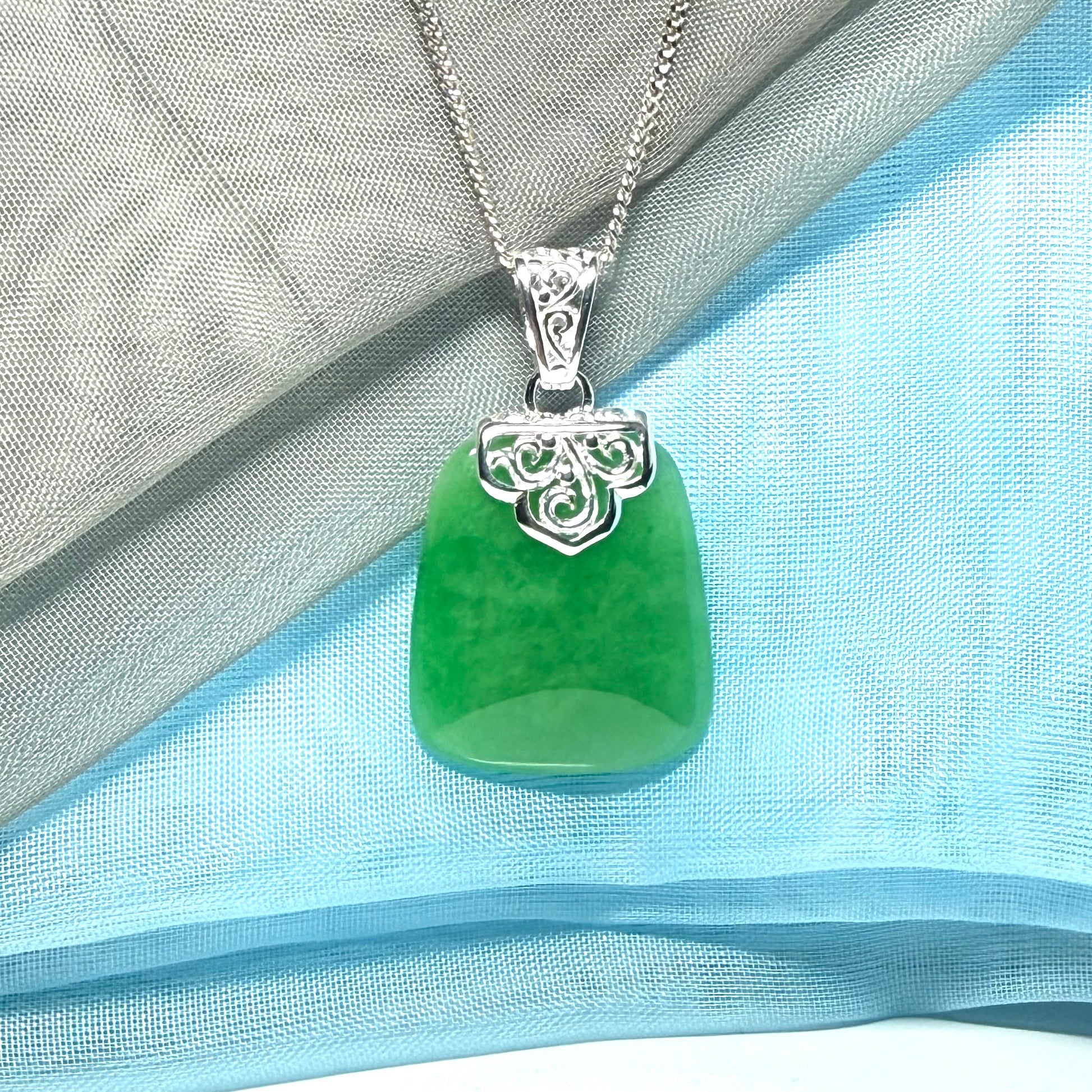 A stunning real green jade necklace with a large shaped and patterned pendant