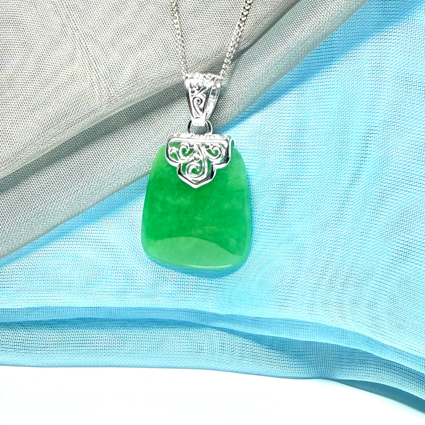 A stunning real green jade necklace with a large shaped and patterned pendant