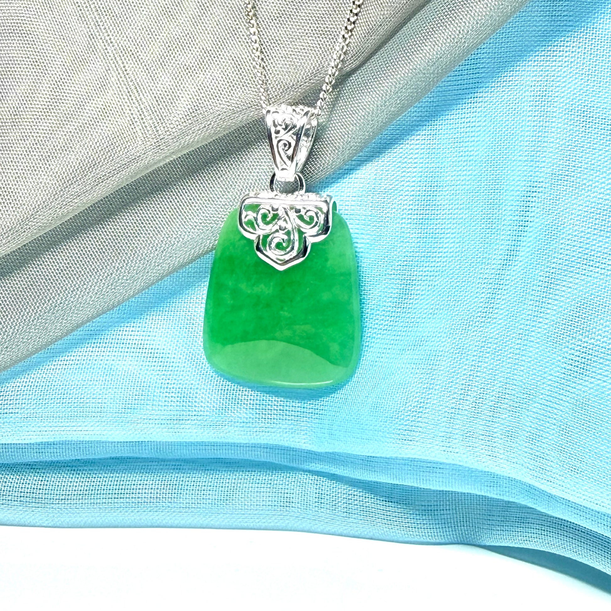 A stunning real green jade necklace with a large shaped and patterned pendant