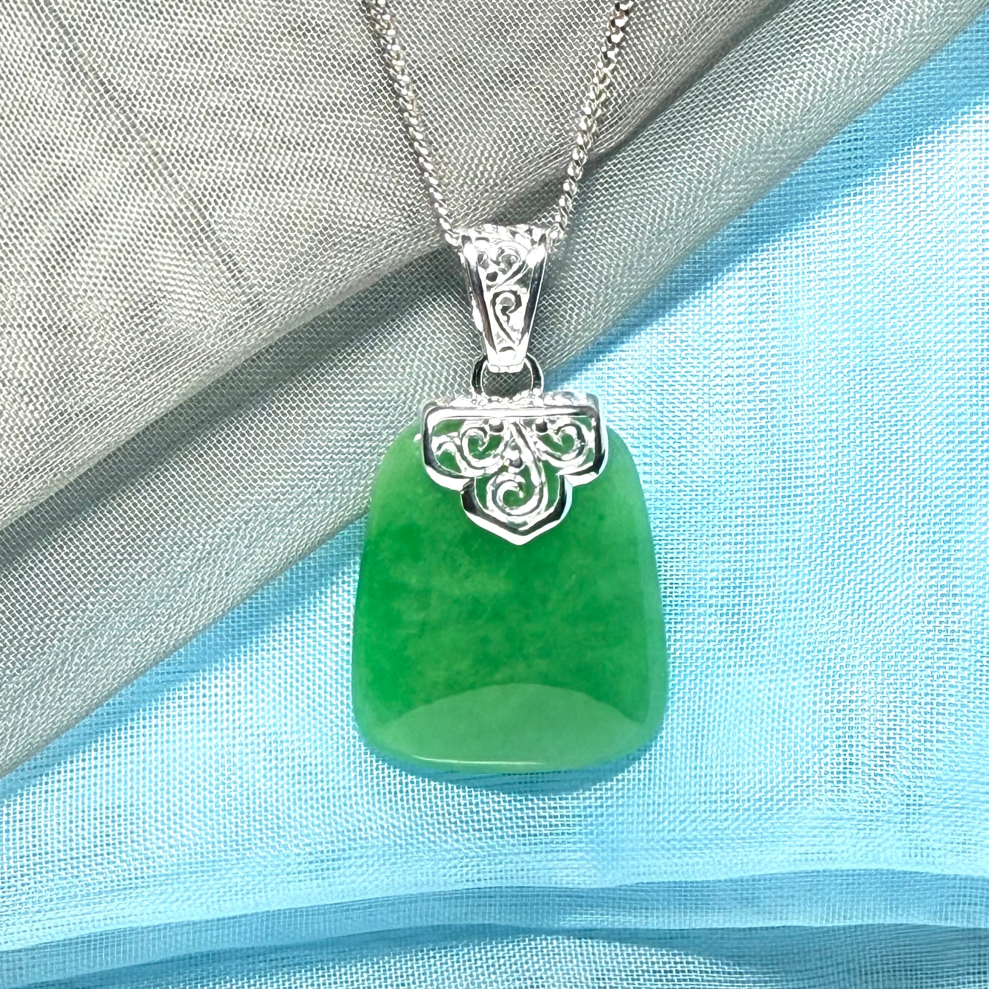 A stunning real green jade necklace with a large shaped and patterned pendant