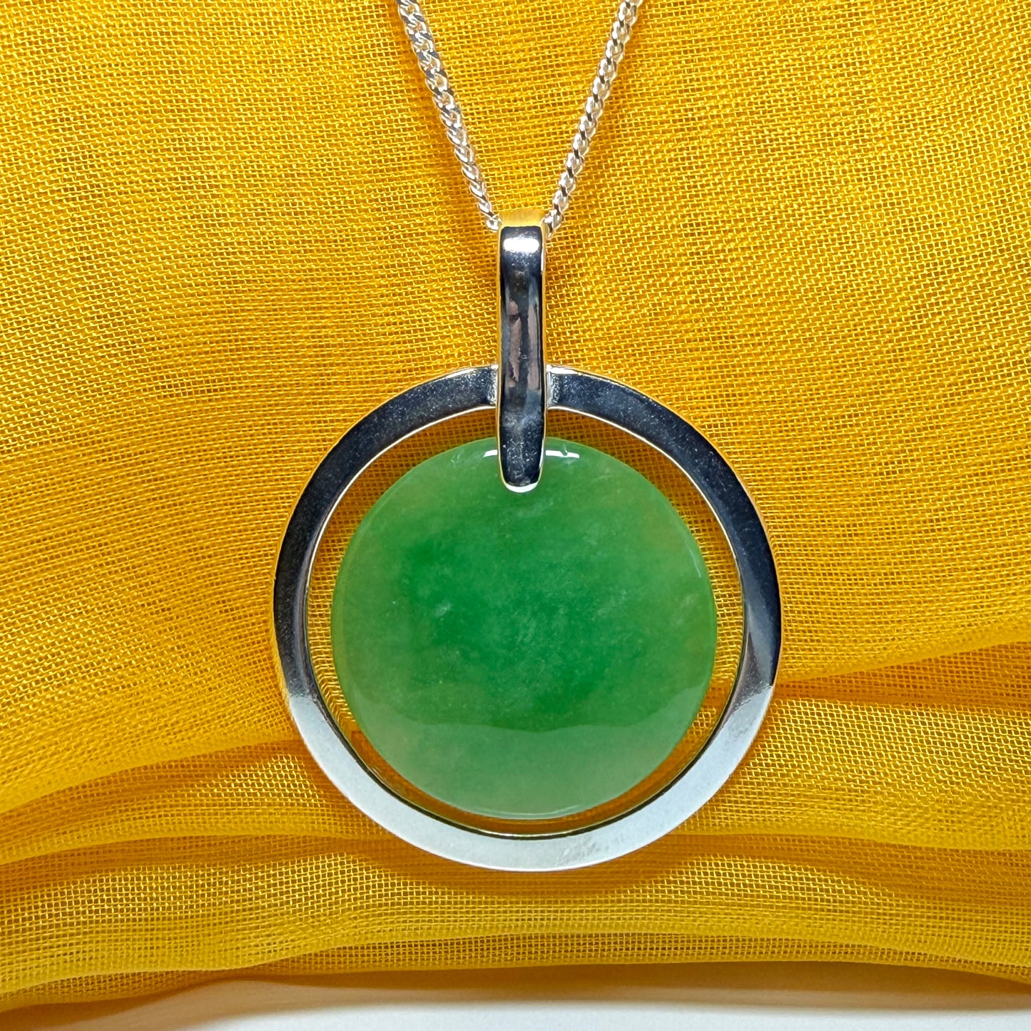 A stunning, shimmering large round halo necklace sterling silver circle shaped green real jade