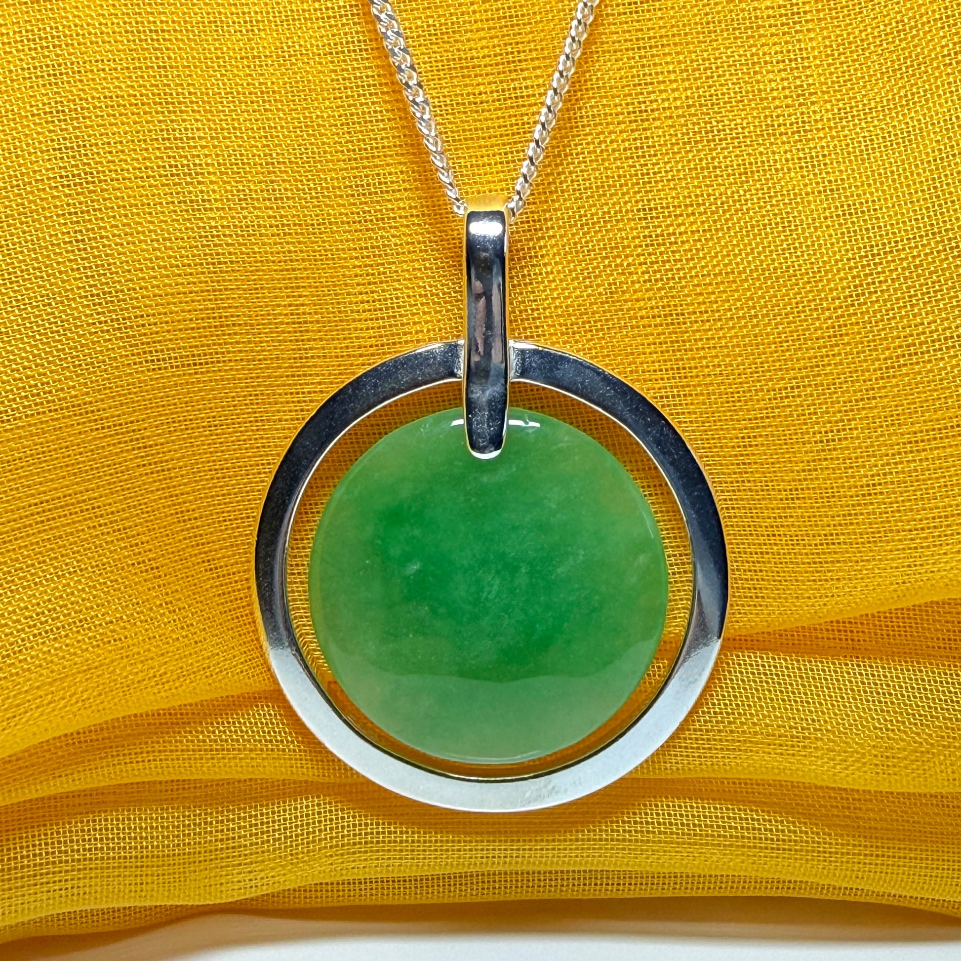 A stunning, shimmering large round halo necklace sterling silver circle shaped green real jade