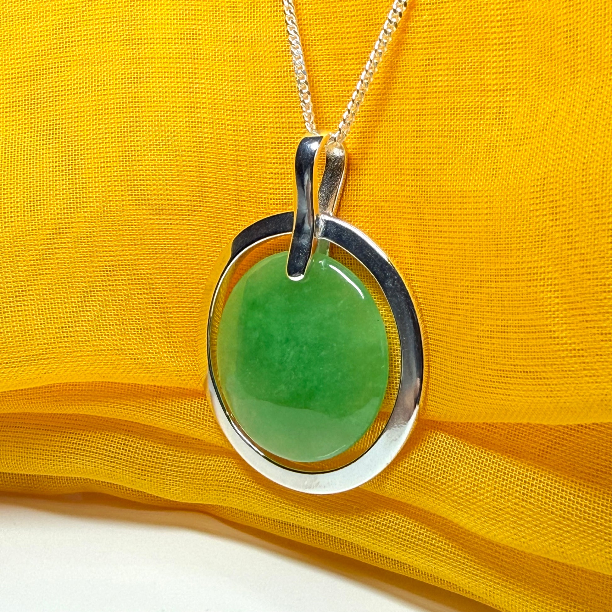 A stunning, shimmering large round halo necklace sterling silver circle shaped green real jade