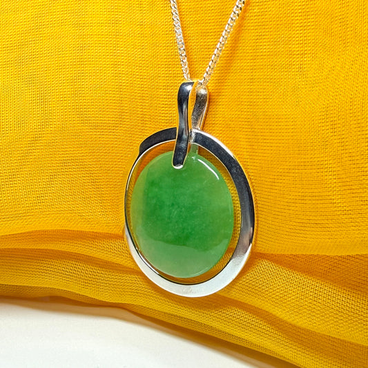 A stunning, shimmering large round halo necklace sterling silver circle shaped green real jade