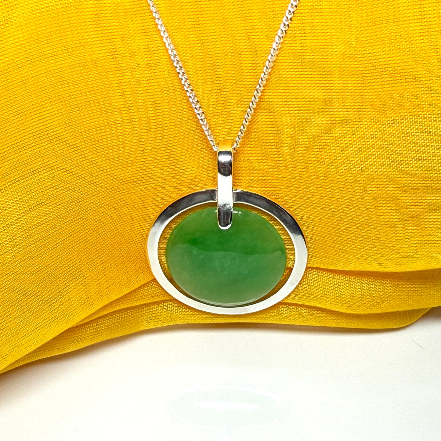 A stunning, shimmering large round halo necklace sterling silver circle shaped green real jade with chain