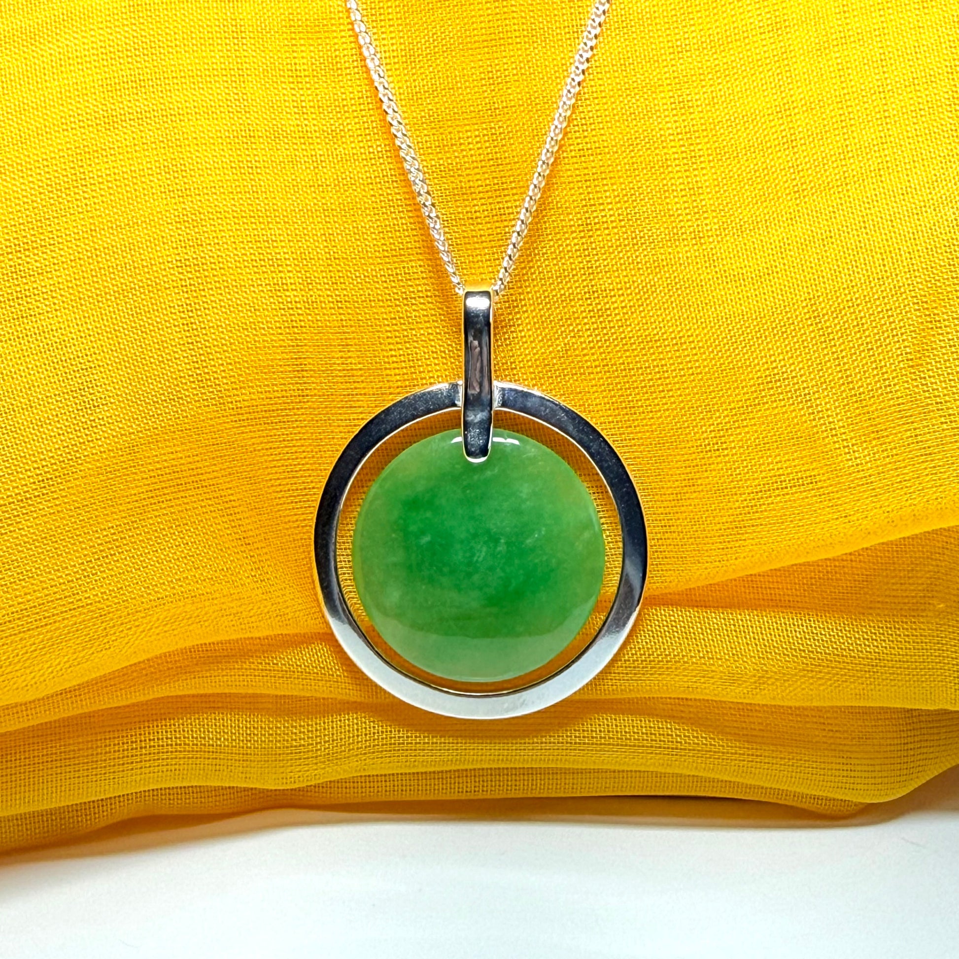 A stunning, shimmering large round halo necklace sterling silver circle shaped green real jade