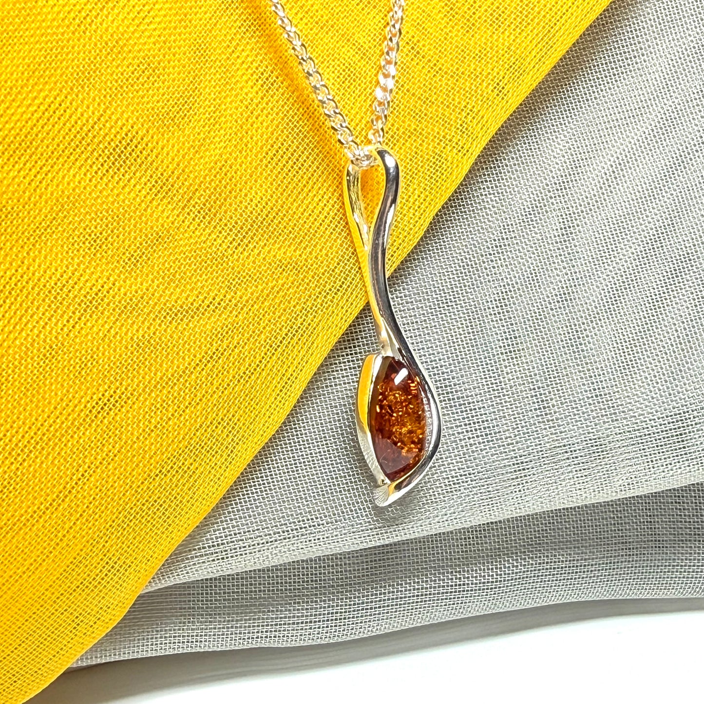 A Sterling silver real amber marquise shaped necklace swirled pendant
