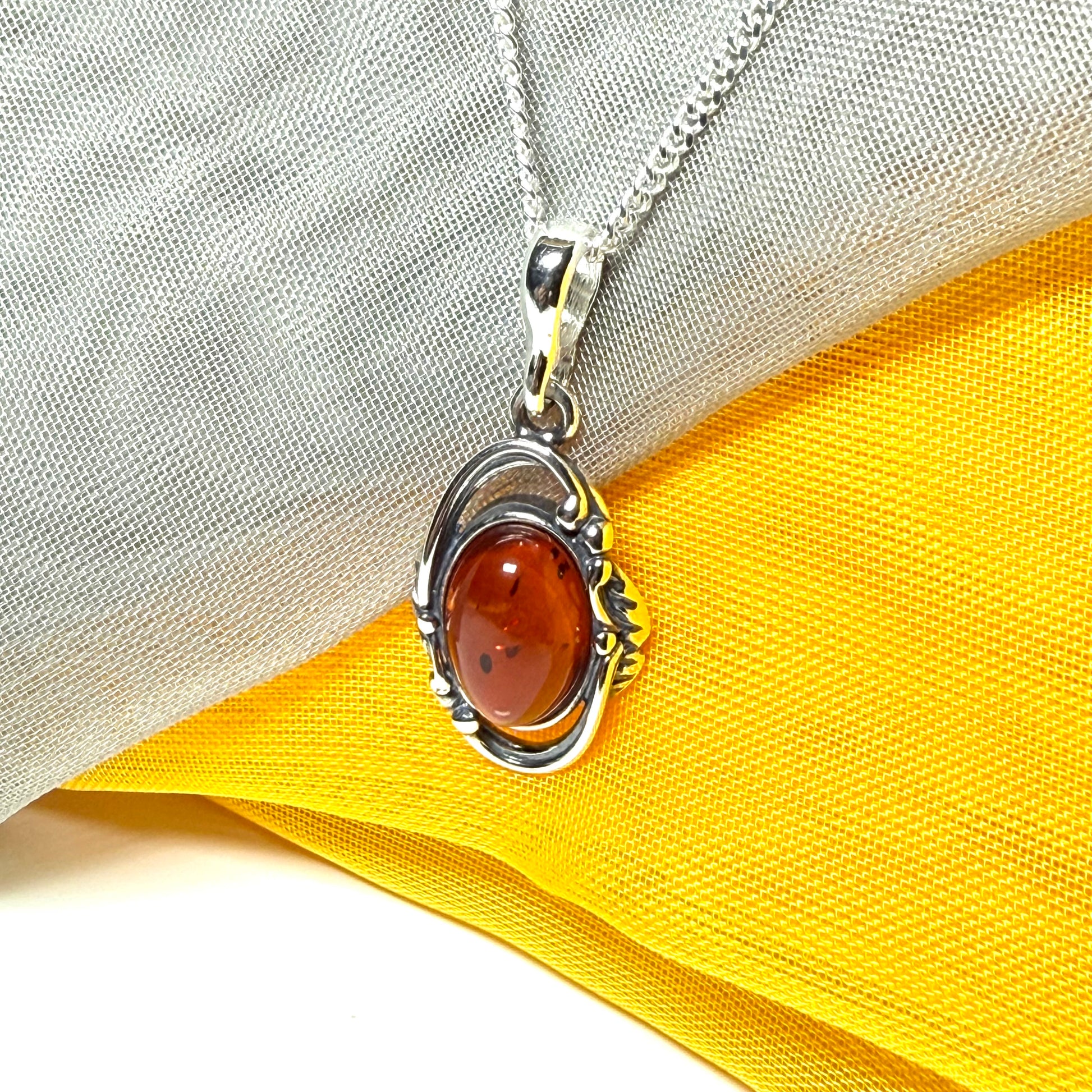 Orange real amber oval sterling silver necklace with a swirl set open pendant With chain
