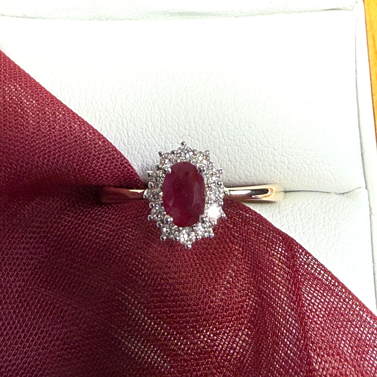 An oval red real ruby and diamond yellow gold cluster ring