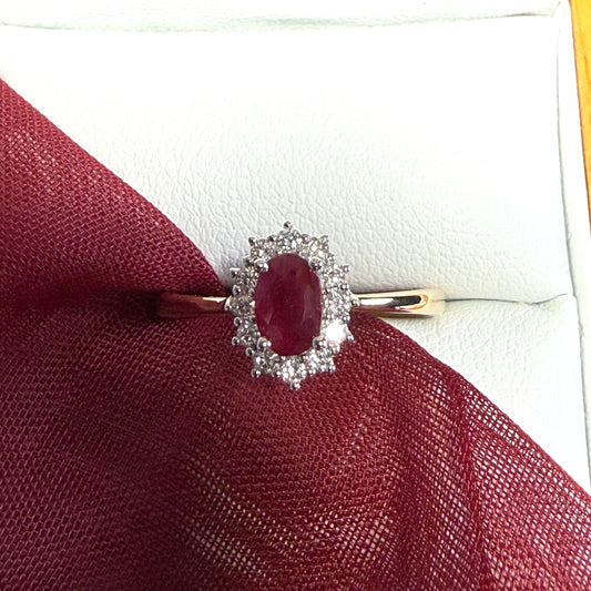 An oval red real ruby and diamond yellow gold cluster ring