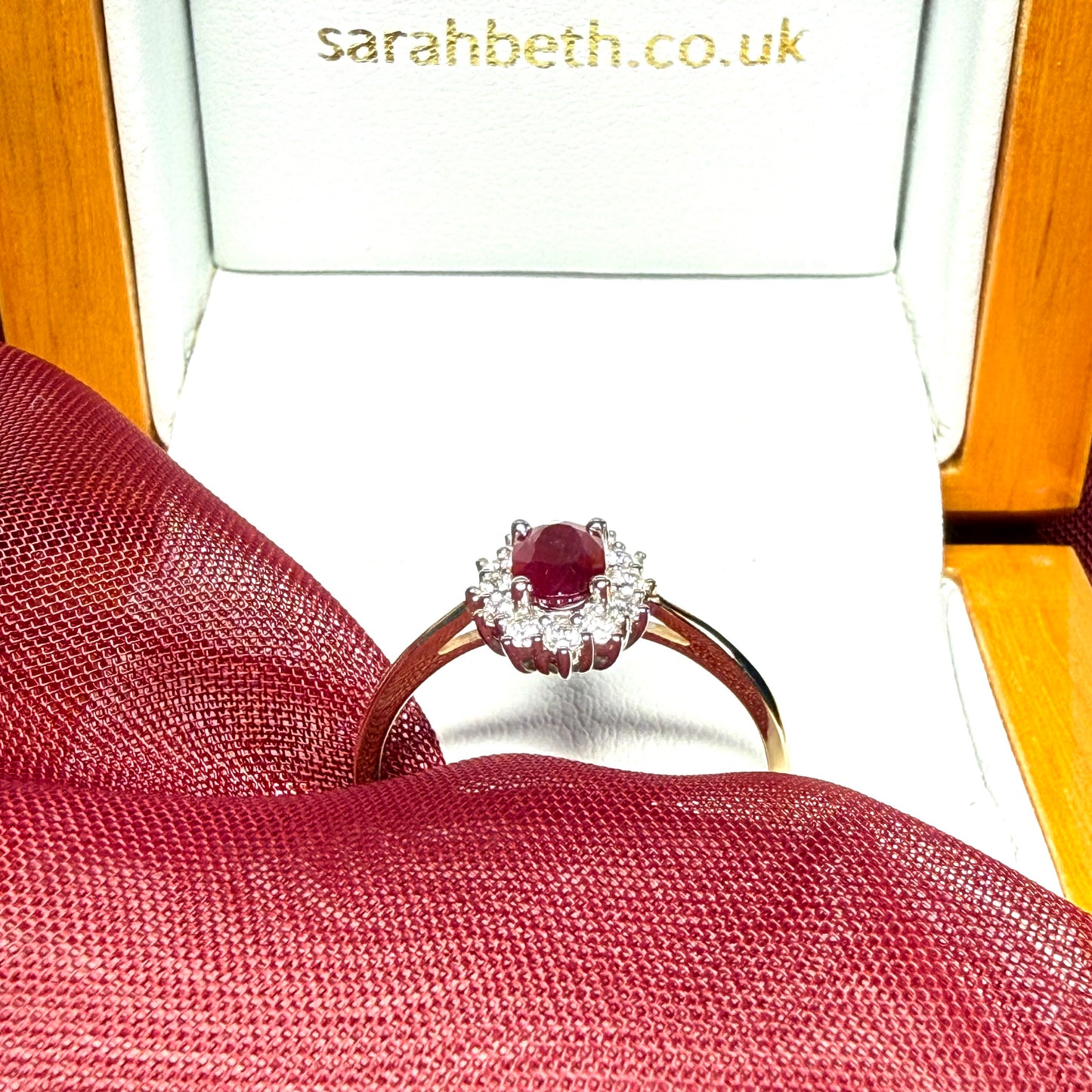 An oval red real ruby and diamond yellow gold cluster ring