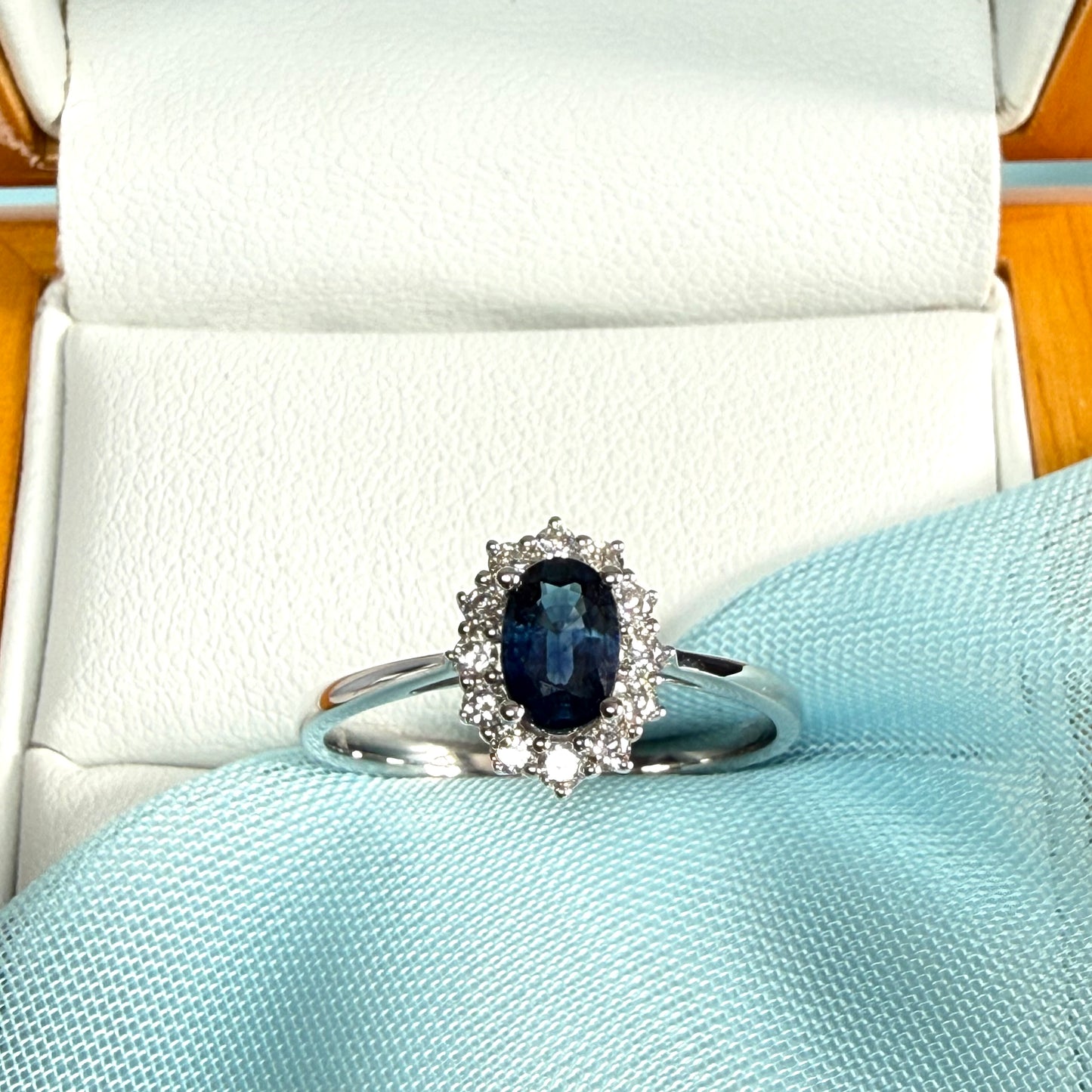 An oval shaped Blue Real Sapphire and Diamond White Gold Cluster Ring