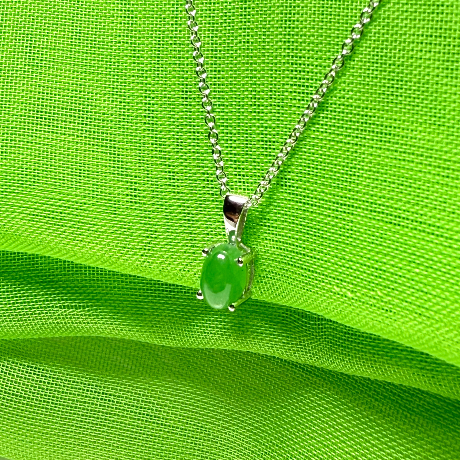 An oval shaped real green jade necklace white gold including chain