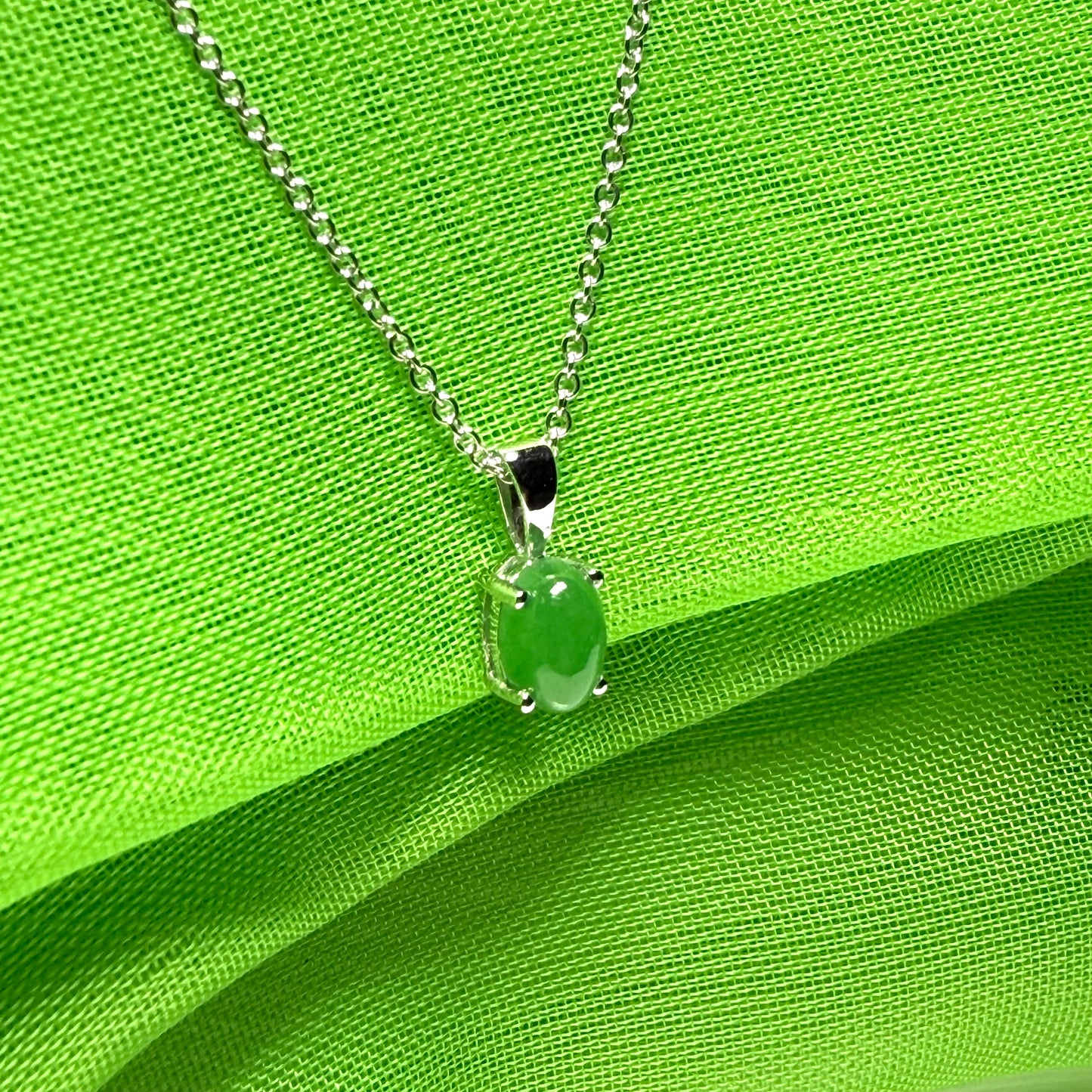 An oval shaped real green jade necklace white gold including chain