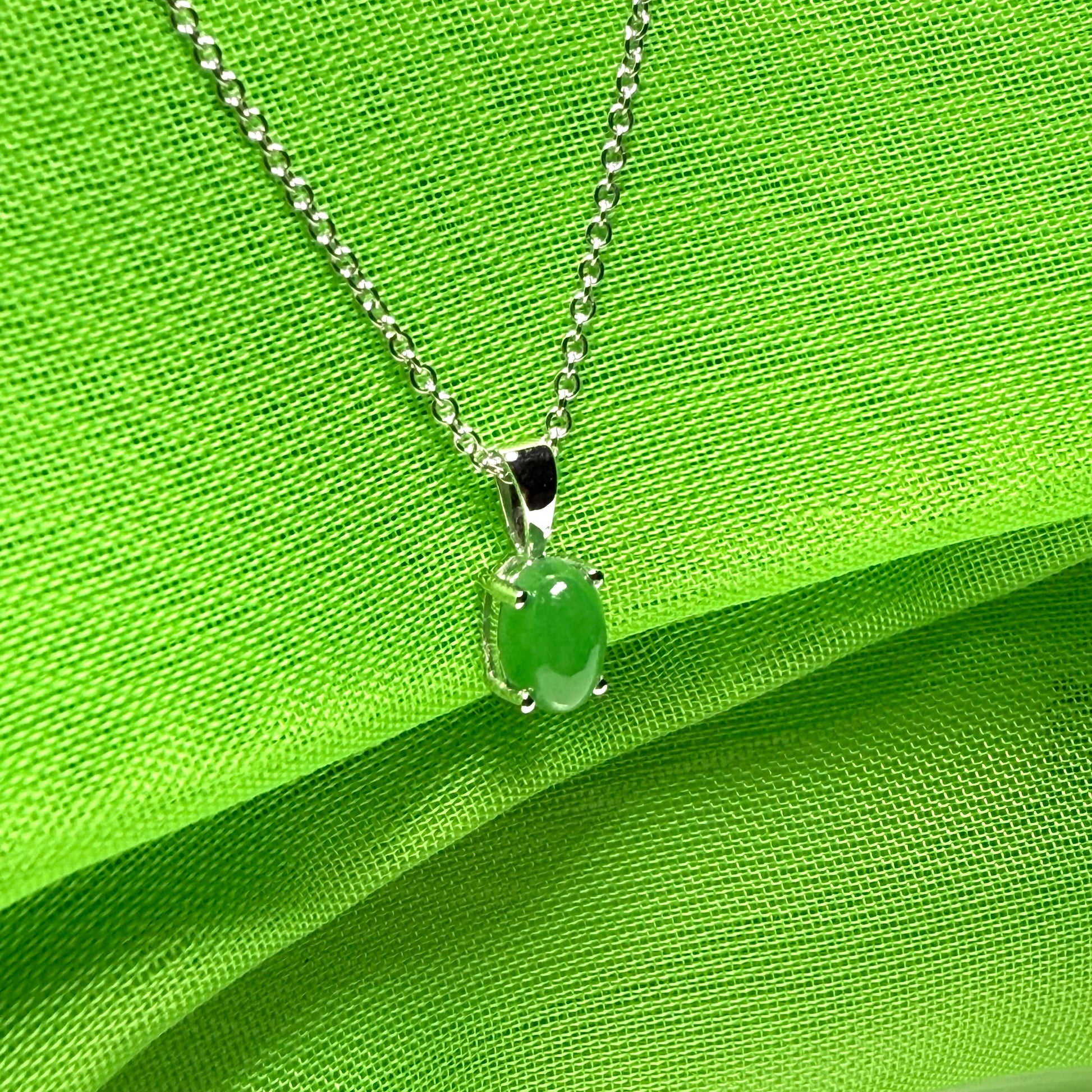 An oval shaped real green jade necklace white gold including chain